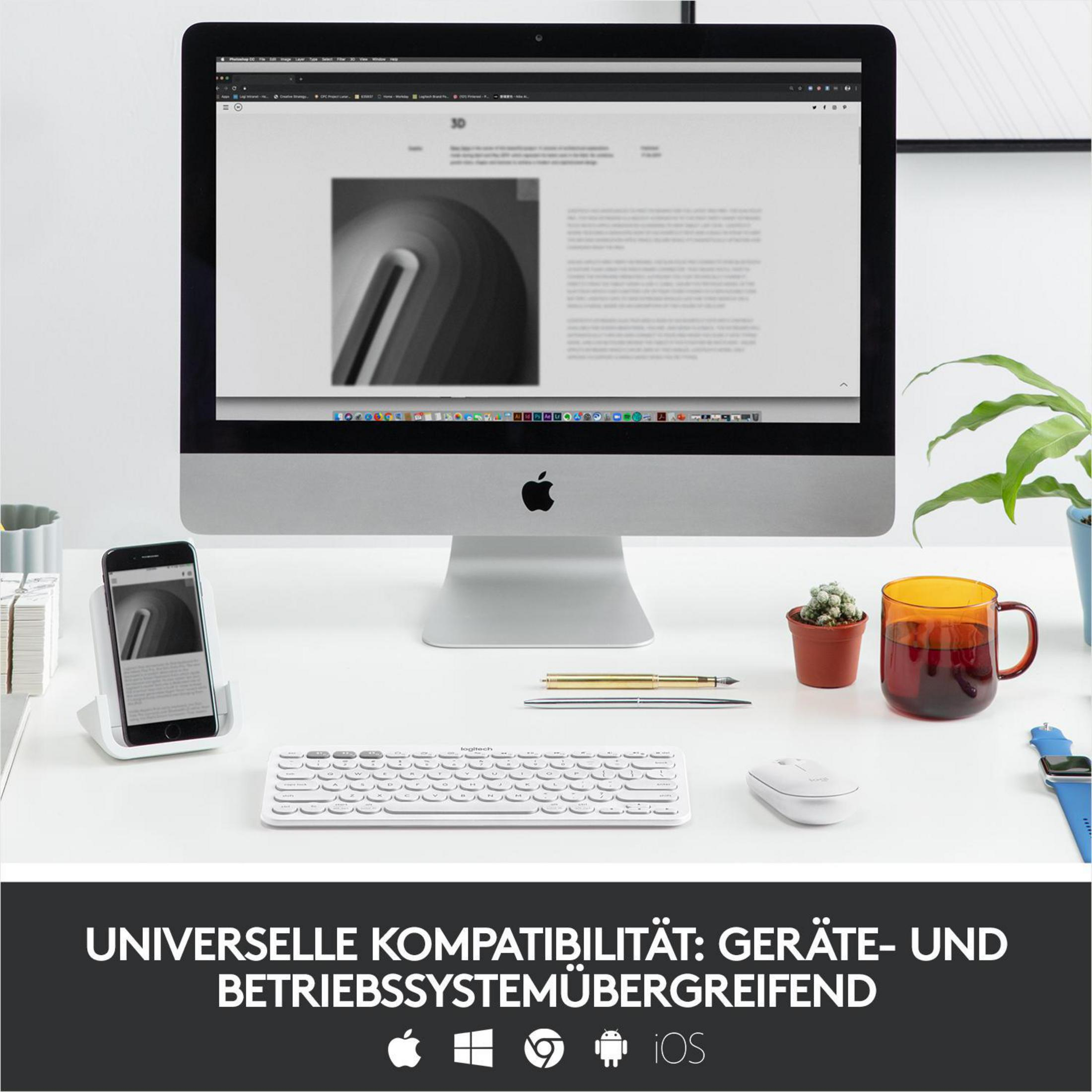 Biurko z komputerem, telefonem, klawiaturą, myszą i innymi przedmiotami. Klawiatura jest biała.