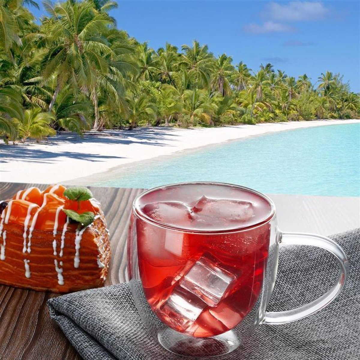 Strandszene mit Kuchen und Getränk. Kuchen mit Obstbelag, Getränk mit Eis.