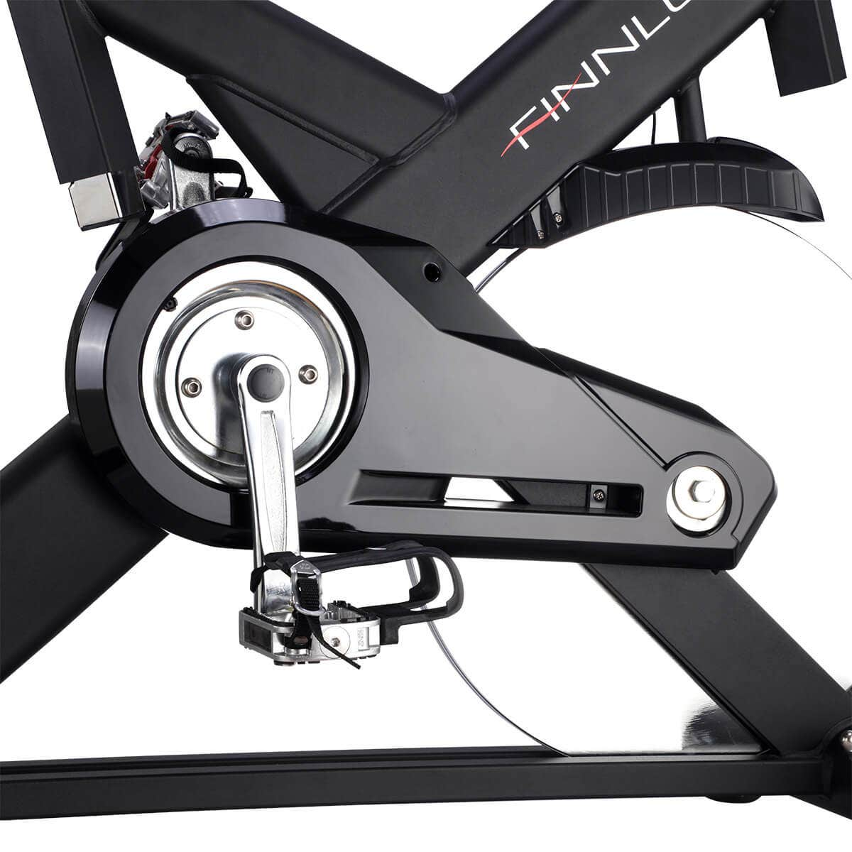 Nahaufnahme des Mechanismus und Pedals eines schwarzen Heimtrainers. Der Markenname 'FINNLO' ist sichtbar.
