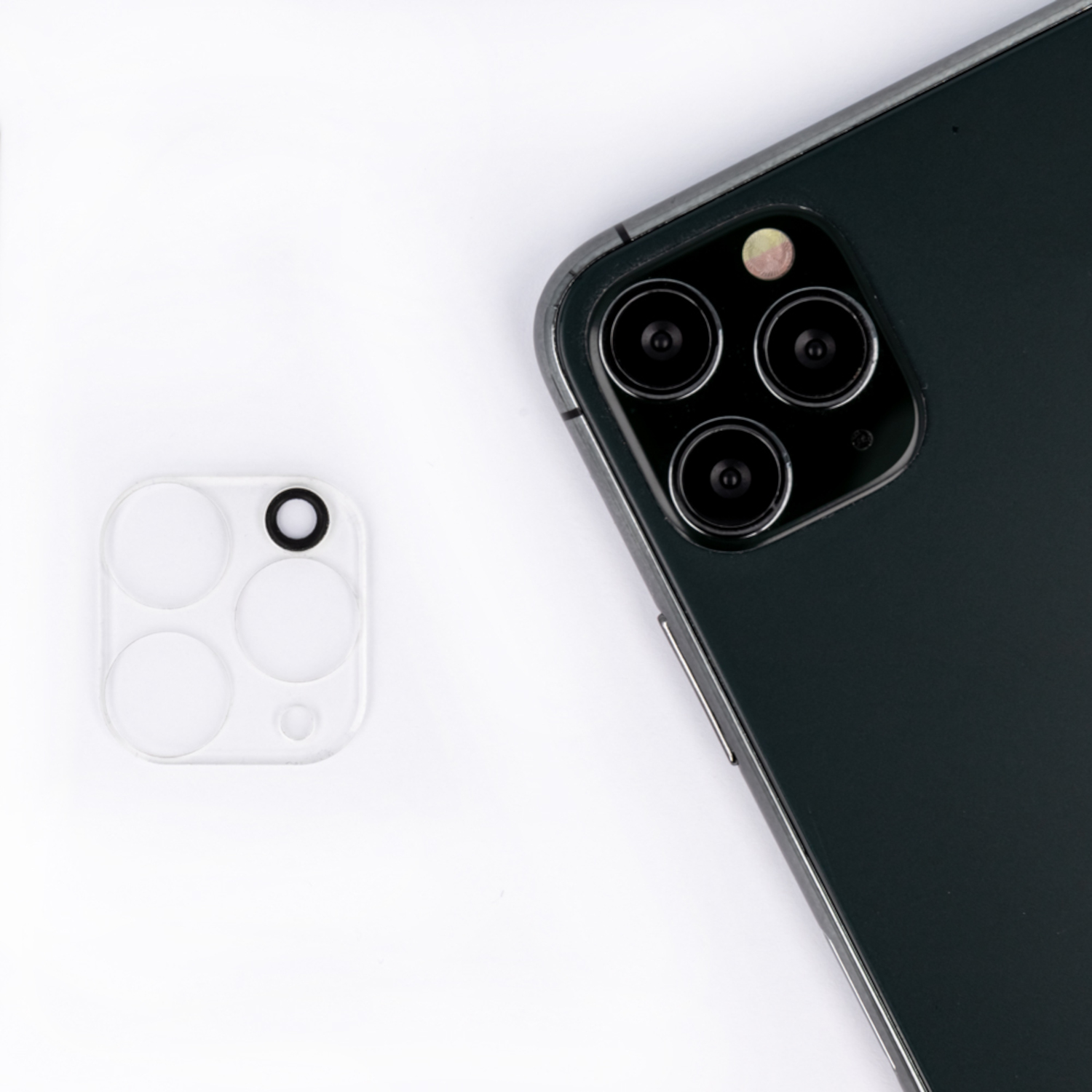 Telefon mit Objektivschutz daneben, weißer Hintergrund.