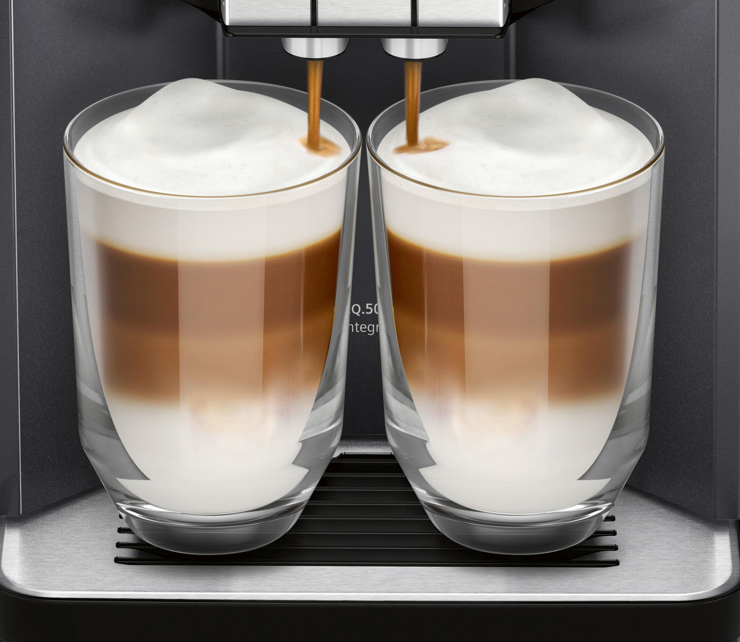 Zwei Gläser Latte mit Schaum. Kaffee wird in die Gläser gegossen.