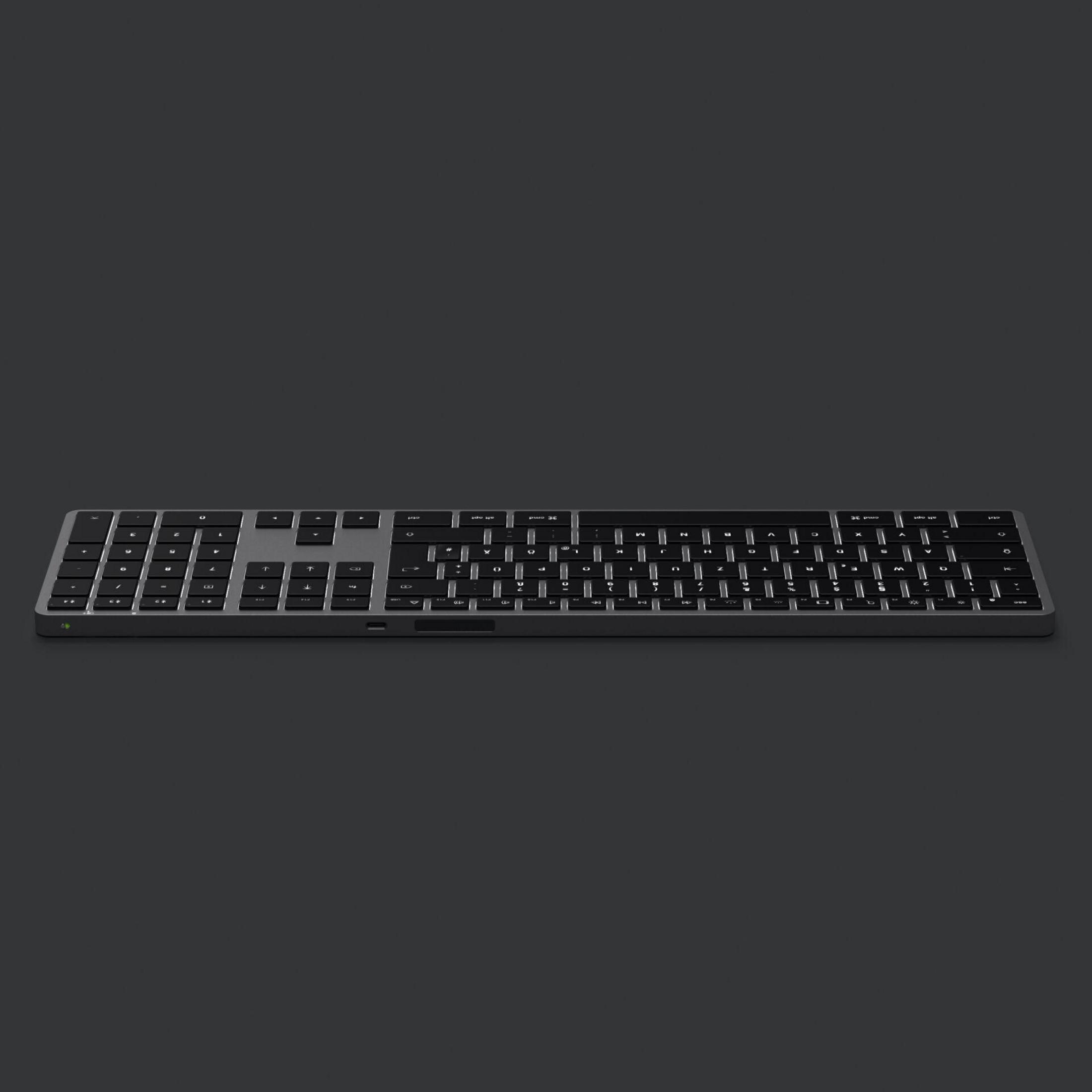 Schwarze Tastatur auf dunkler grauer Oberfläche. Die Tasten sind leicht sichtbar.
