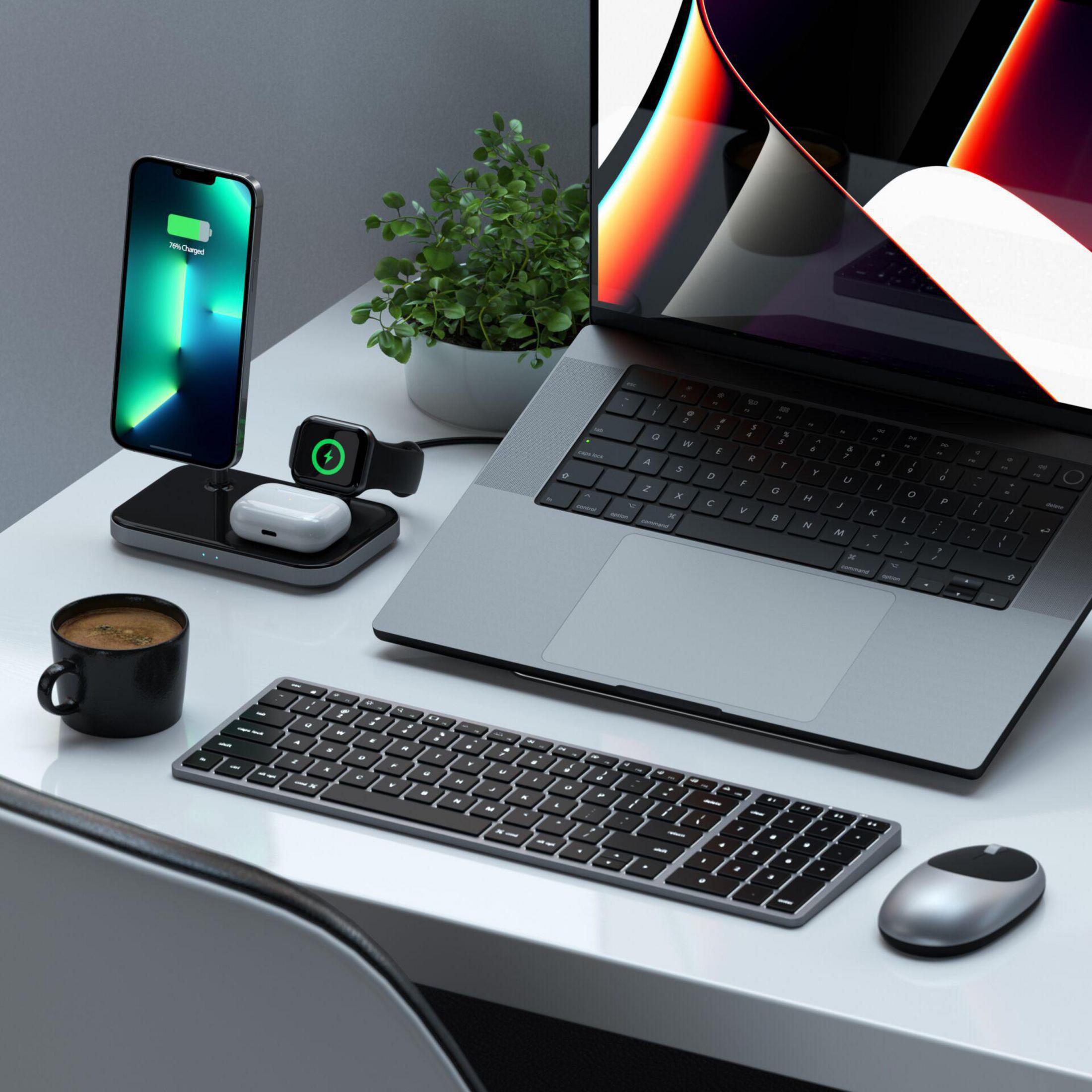 Schreibtisch mit Laptop, Telefon, Uhr, Tastatur, Maus und Kaffee.