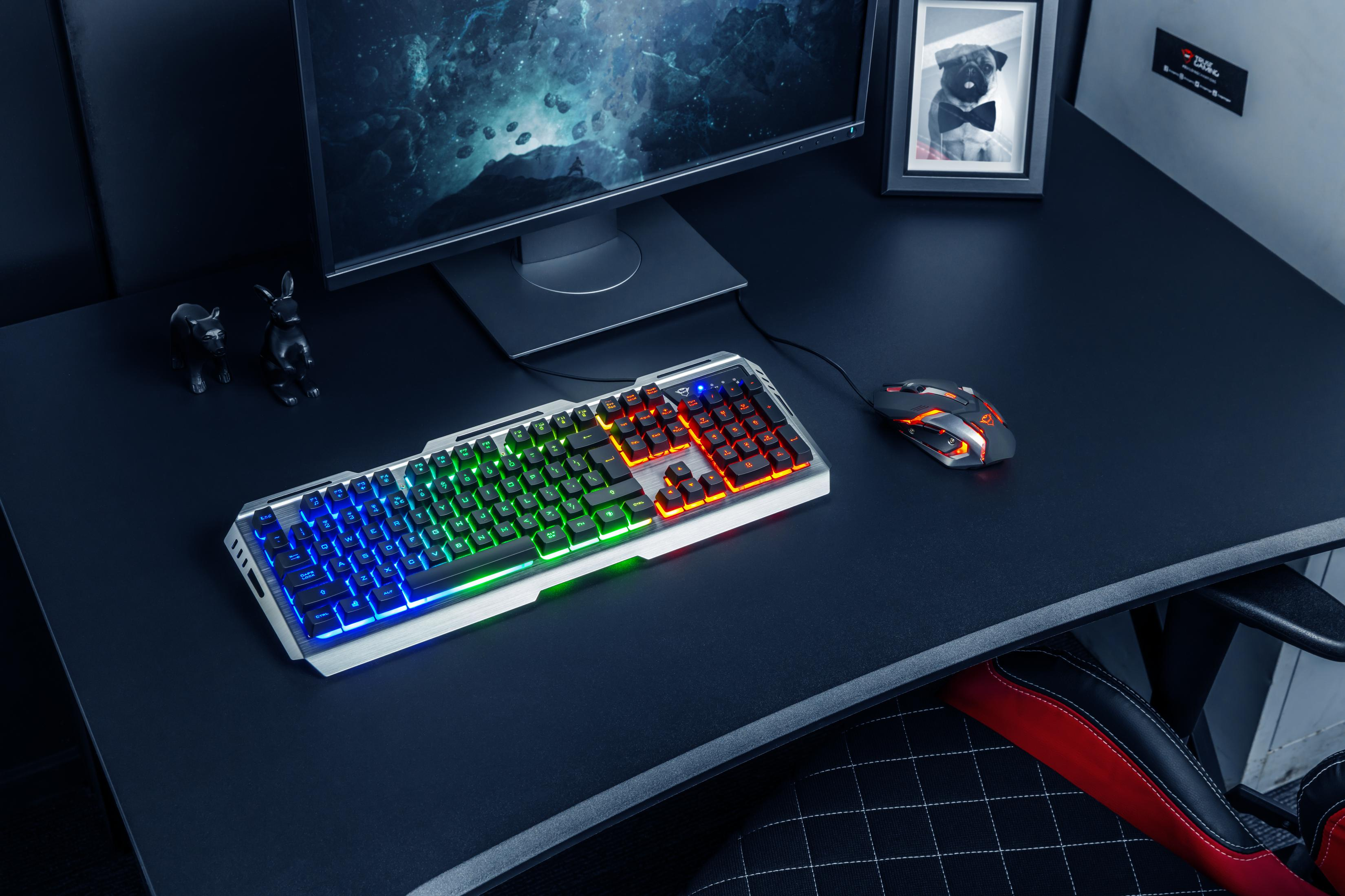 Escritorio de juegos con teclado y ratón. Monitor, decoraciones. Escritorio, silla y pared negros.