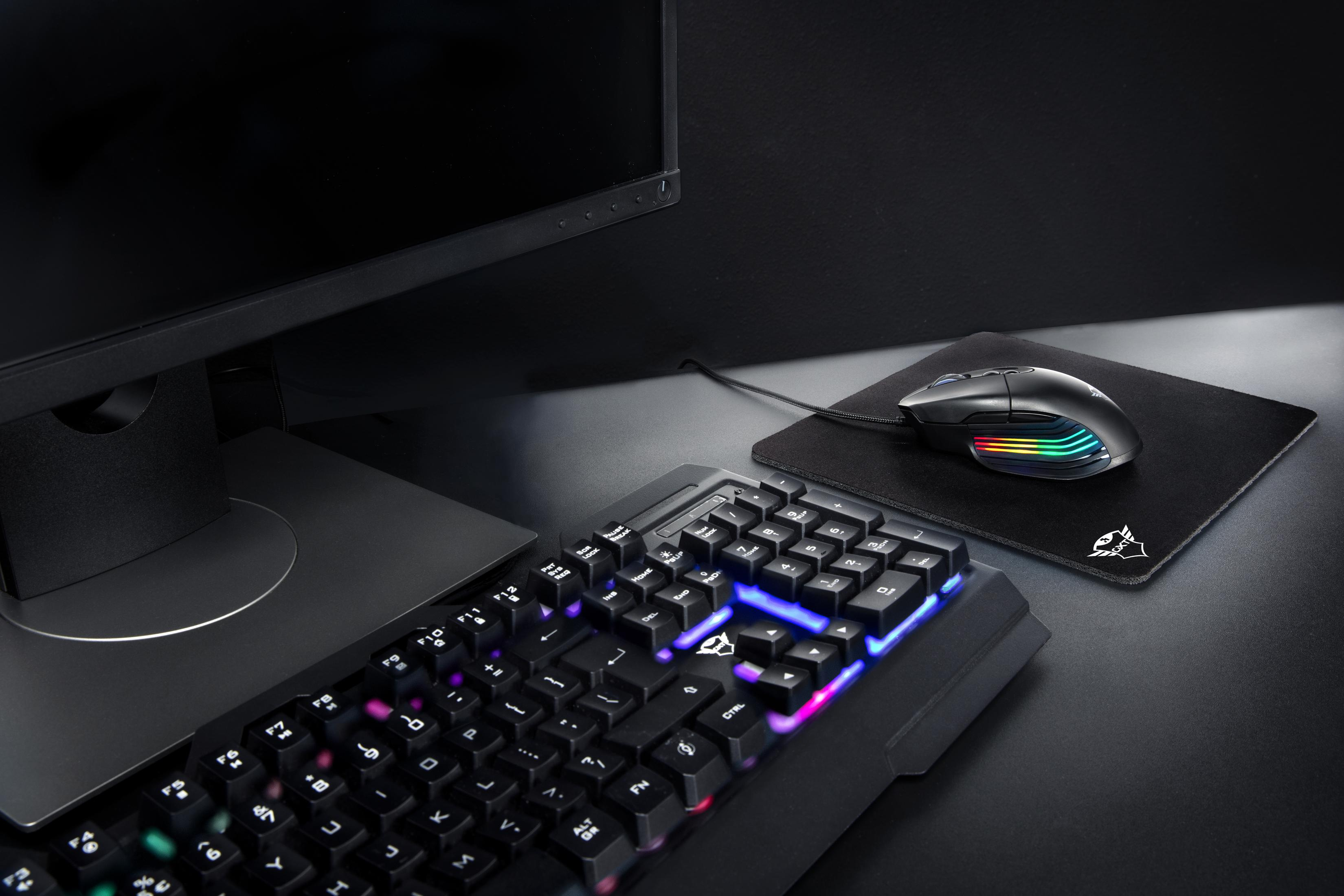 Un'impostazione del computer con monitor, tastiera e mouse su una scrivania. La tastiera è illuminata.