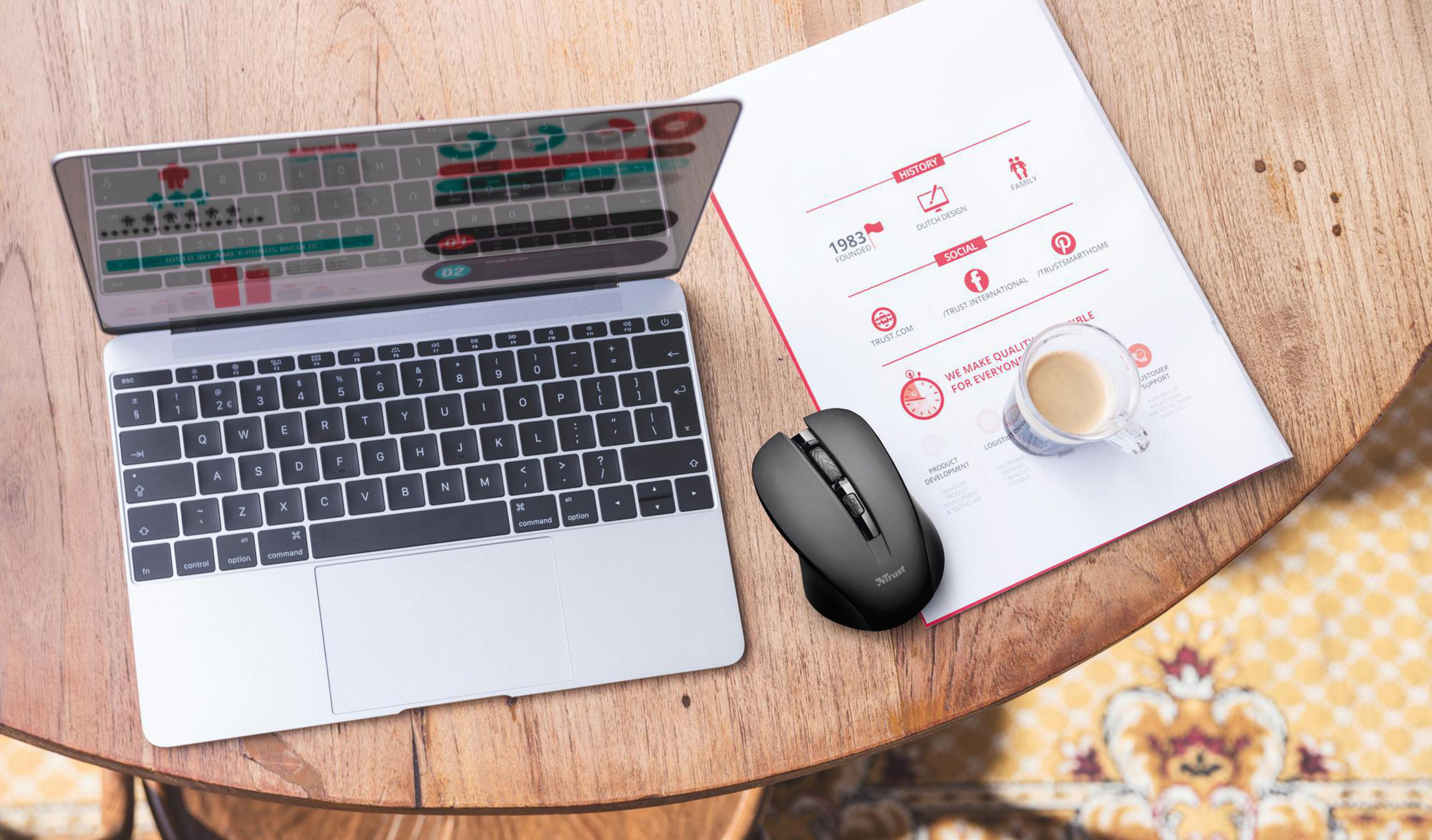 Laptop, mysz, dokument i filiżanka kawy na drewnianym stole.