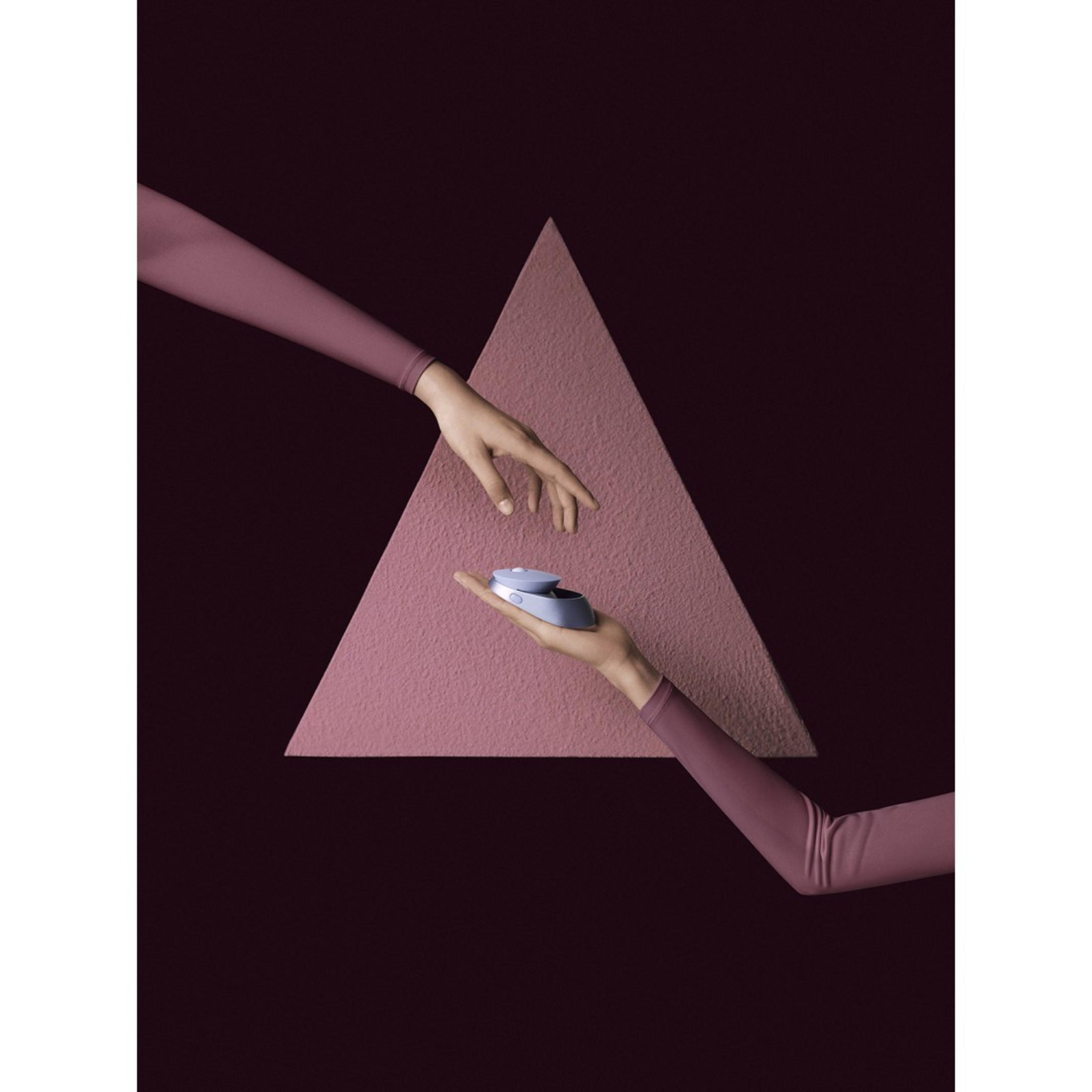 Dos manos alcanzan un objeto azul sobre un fondo de triángulo rosa, fondo granate oscuro.