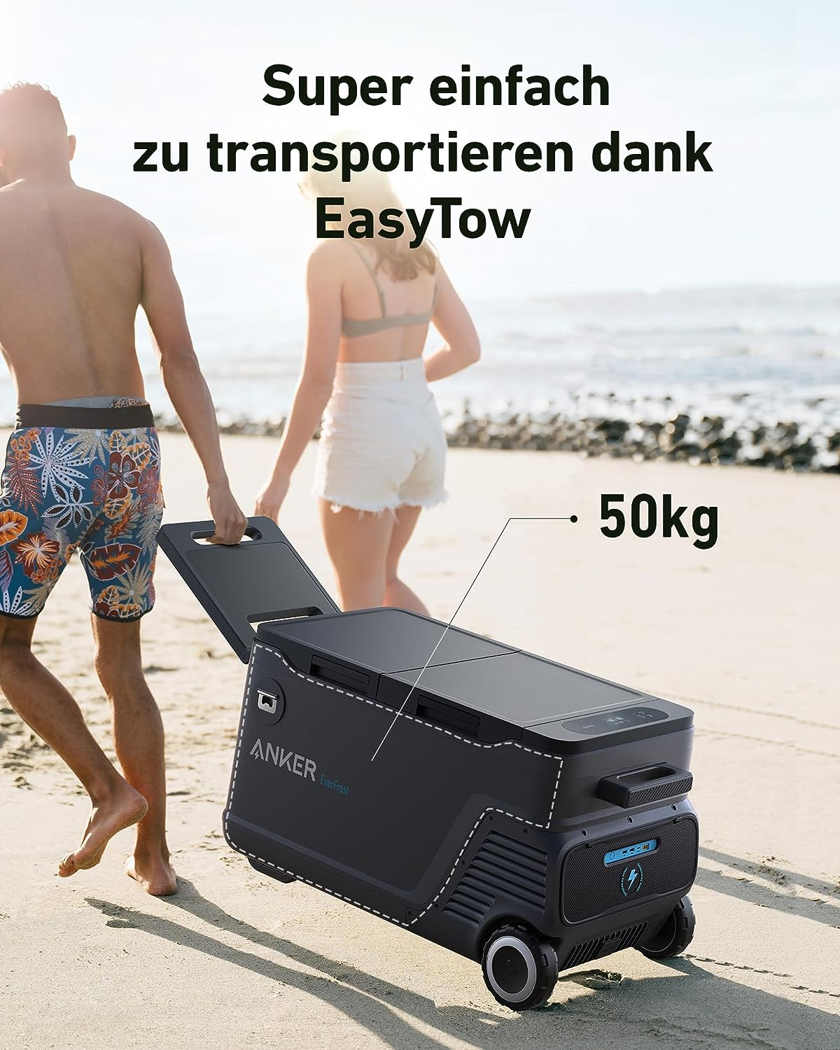 Dos personas caminando por la playa tirando de un refrigerador negro. Texto: Super einfach zu transportieren dank EasyTow. 50kg.