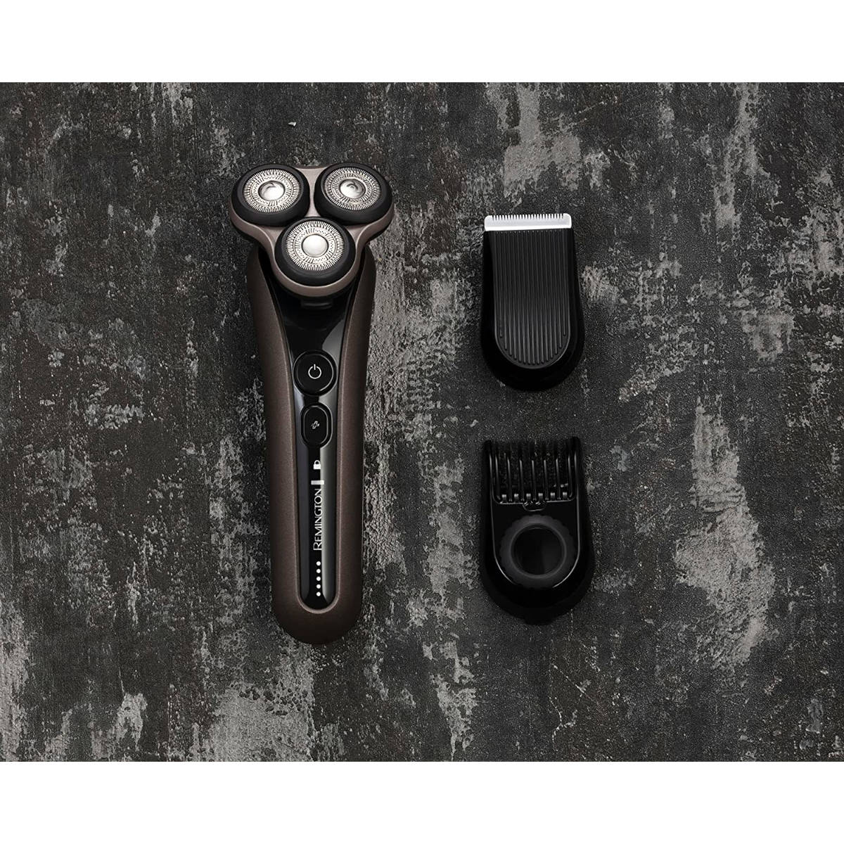 Remington-Rasierer mit drei Köpfen, einem Trimmer und einem Clipper. Alle sind dunkelbraun und schwarz auf grauer Oberfläche.