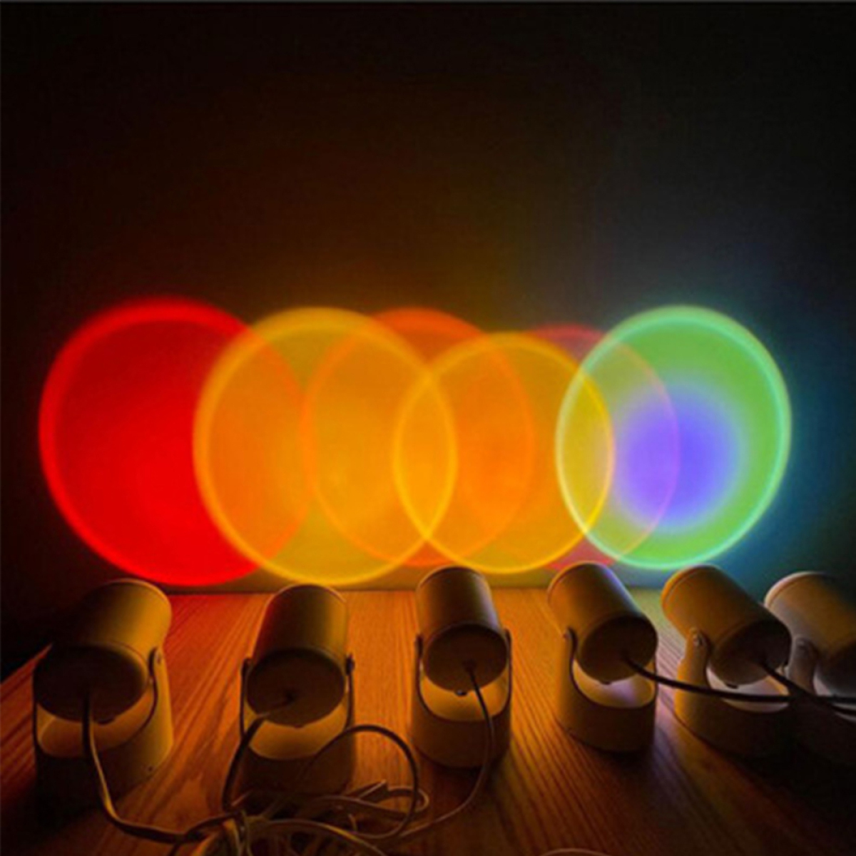 Sechs kleine Lichter, die farbige Kreise auf eine dunkle Oberfläche projizieren. Rot, Orange und Grün sind sichtbar.