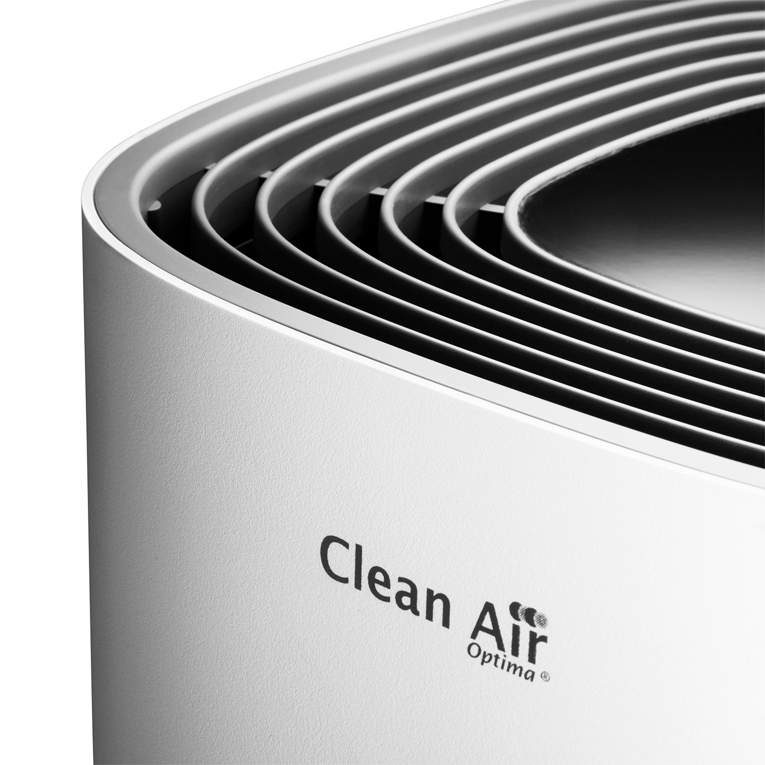 Close-up of a white air purifier. The top has curved vents, the words "Clean Air Optima" visible.