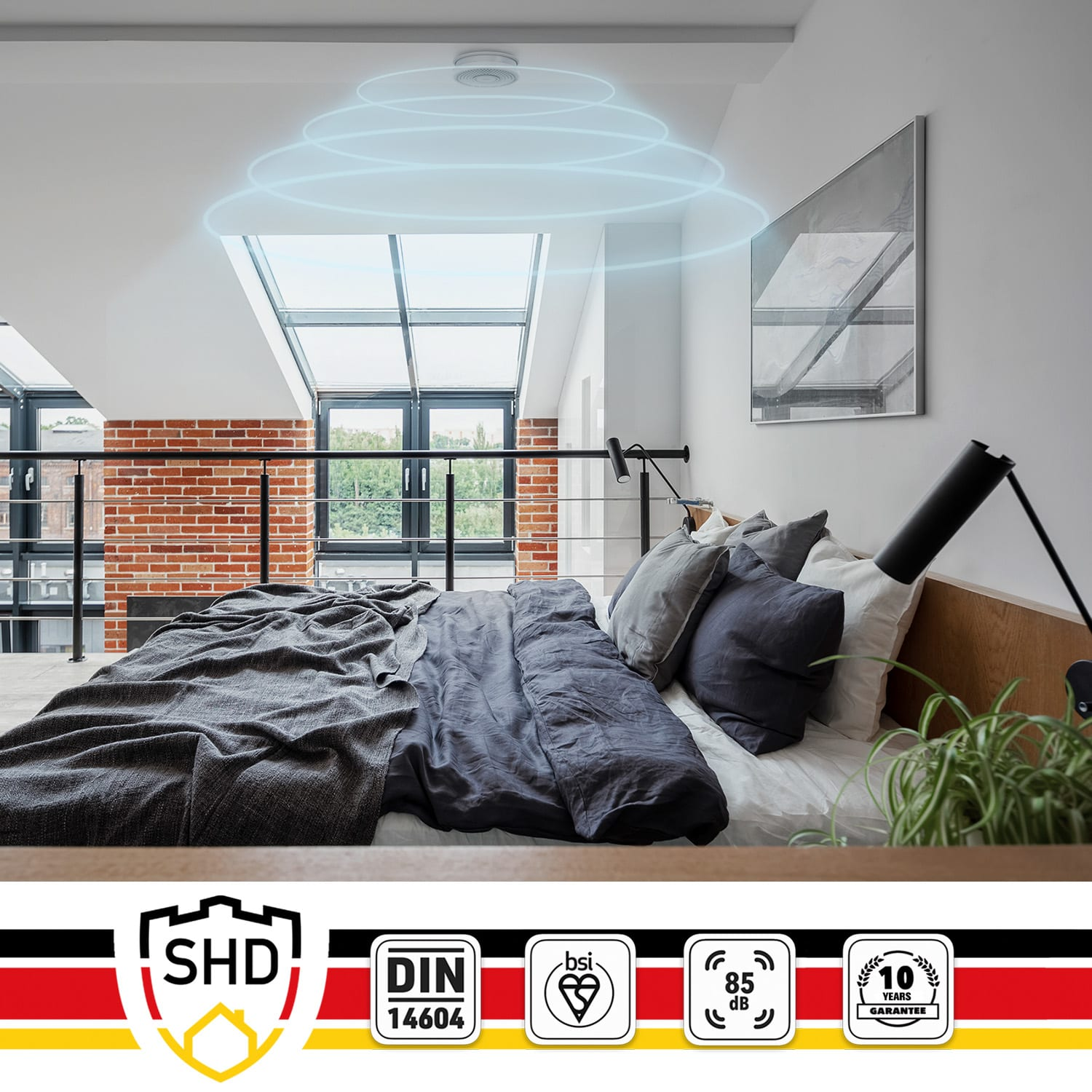 Ein Schlafzimmer mit Rauchmelder an der Decke und einem Bett.
