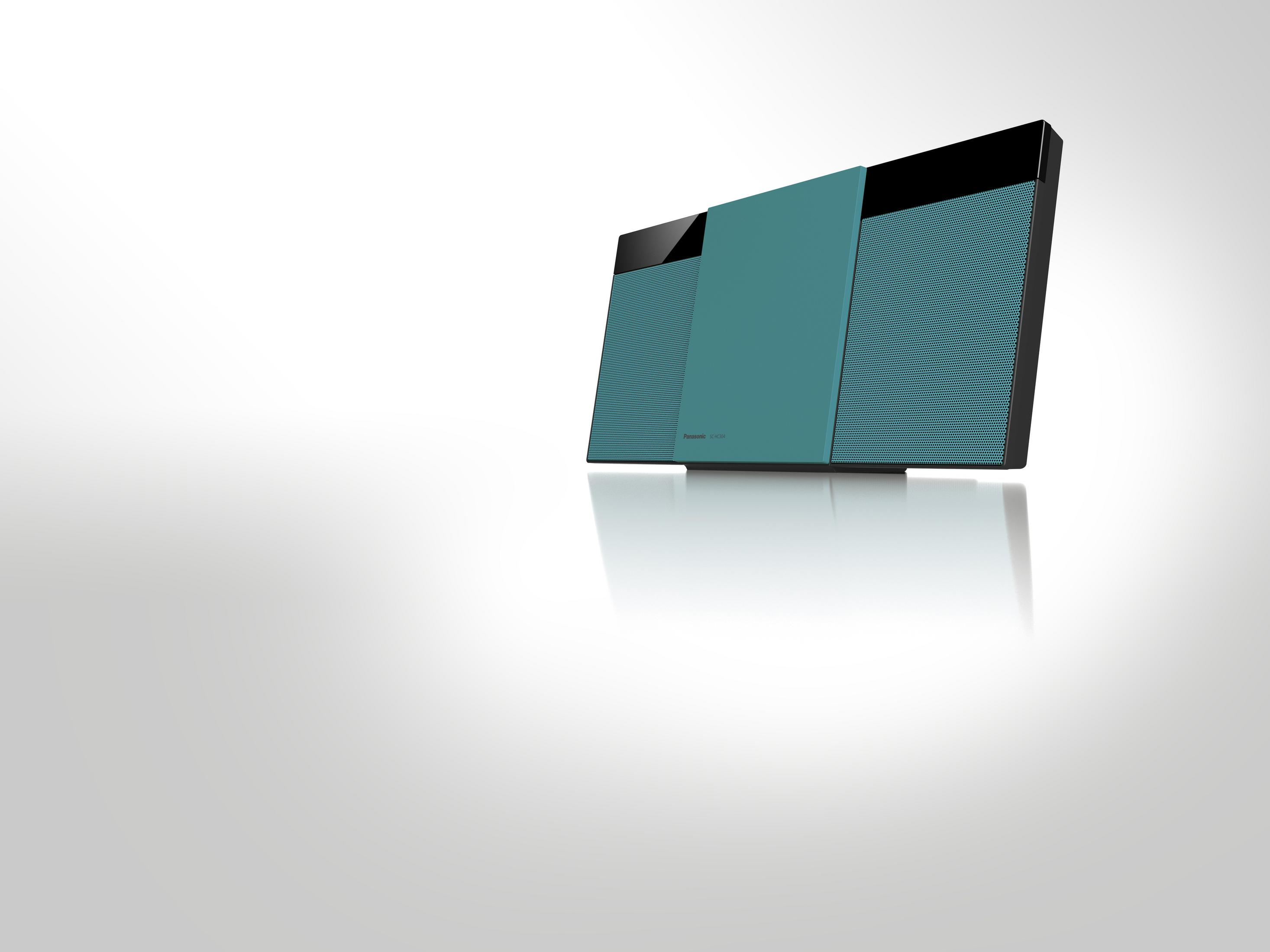 Türkisfarbenes und schwarzes Audiosystem auf weißer, reflektierender Oberfläche.