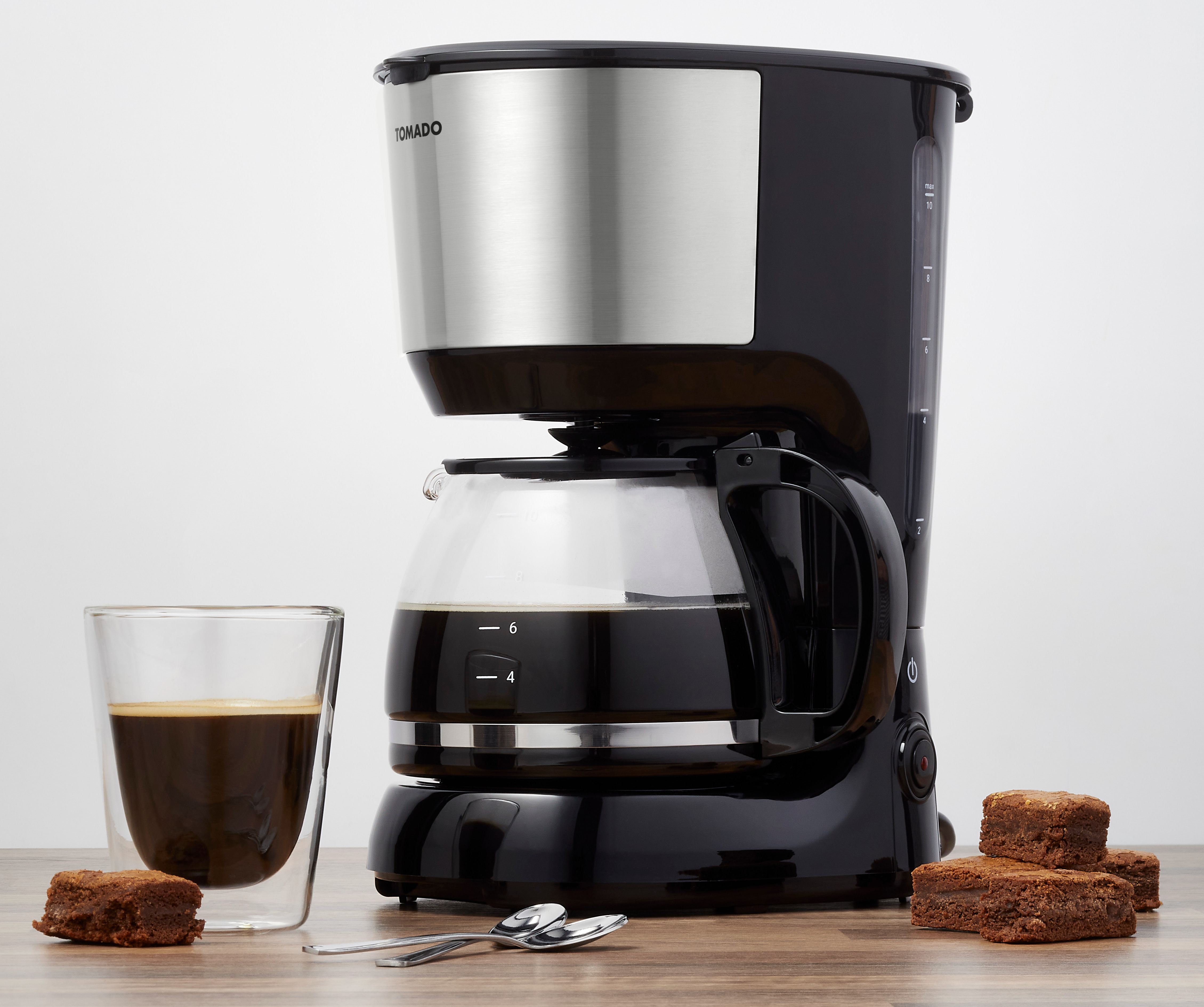 Coffee machine, glass carafe with coffee, and a glass of coffee and brownies.
