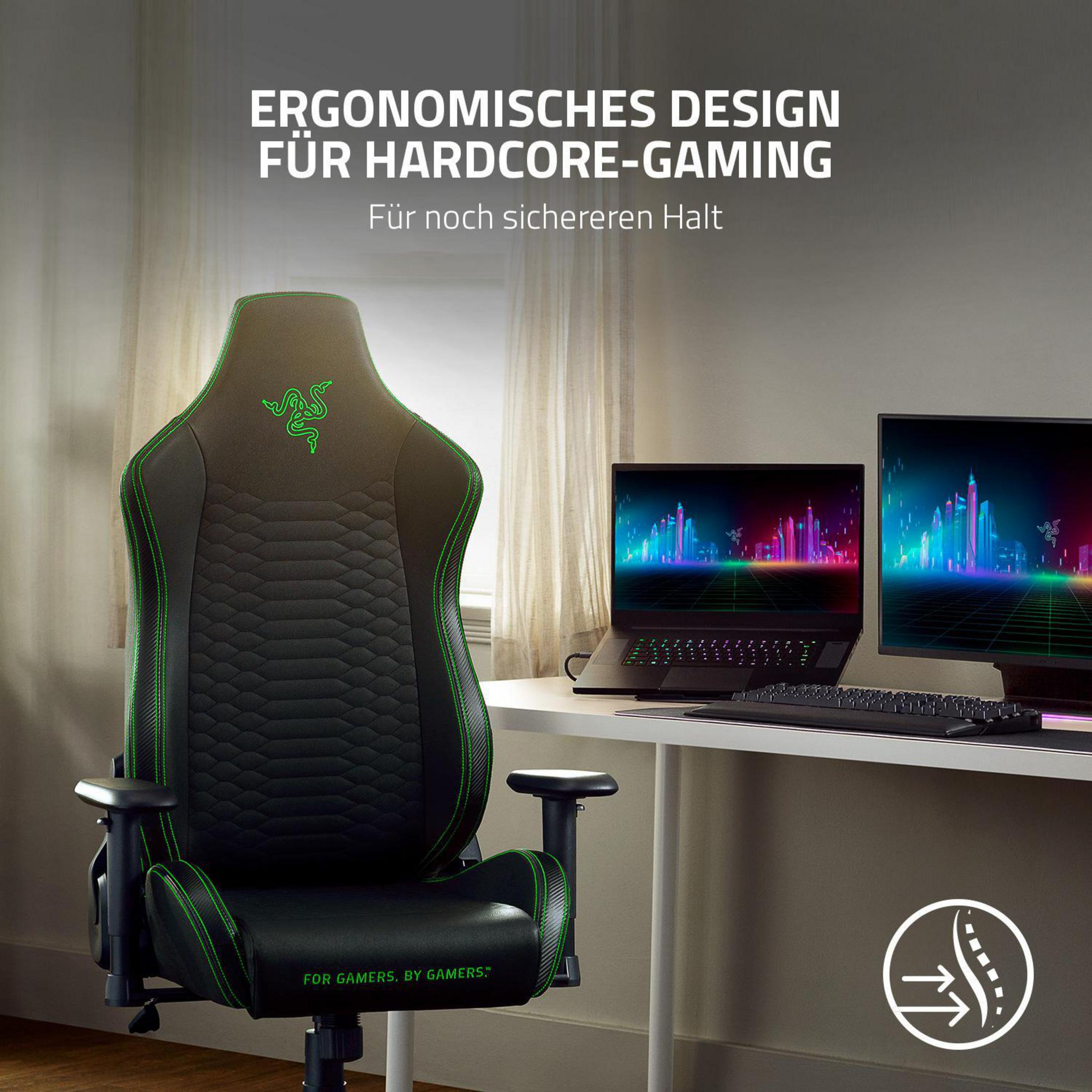 Sedia da gaming nera e verde, scrivania con laptop, monitor, tastiera.