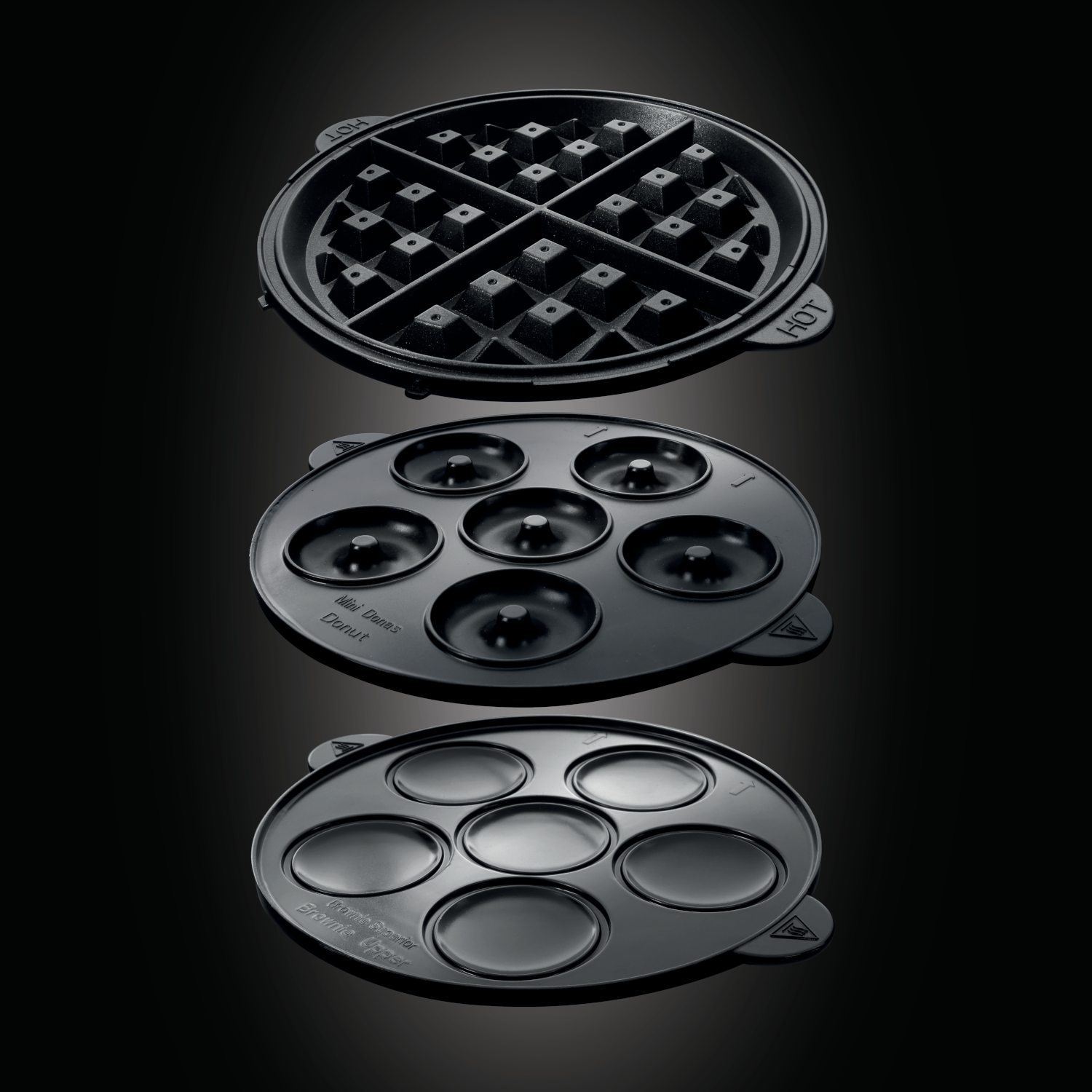 Trzy czarne płyty do gofrownicy o różnych kształtach: gofr, mini pączek i brownie.