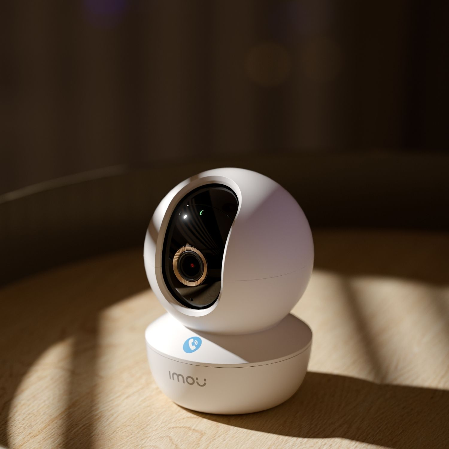 Biała, kulista kamera bezpieczeństwa na drewnianym stole. Kamera ma czarny obiektyw i niebieskie logo.