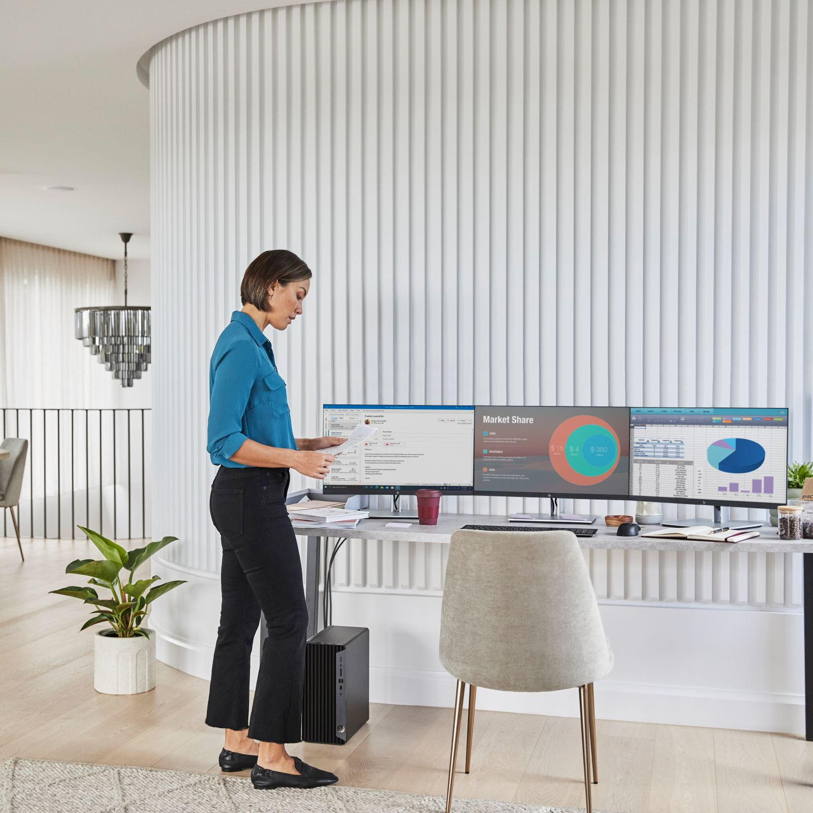 Kobieta pracuje przy biurku z dwoma monitorami. Nowoczesne biuro, neutralne tony.