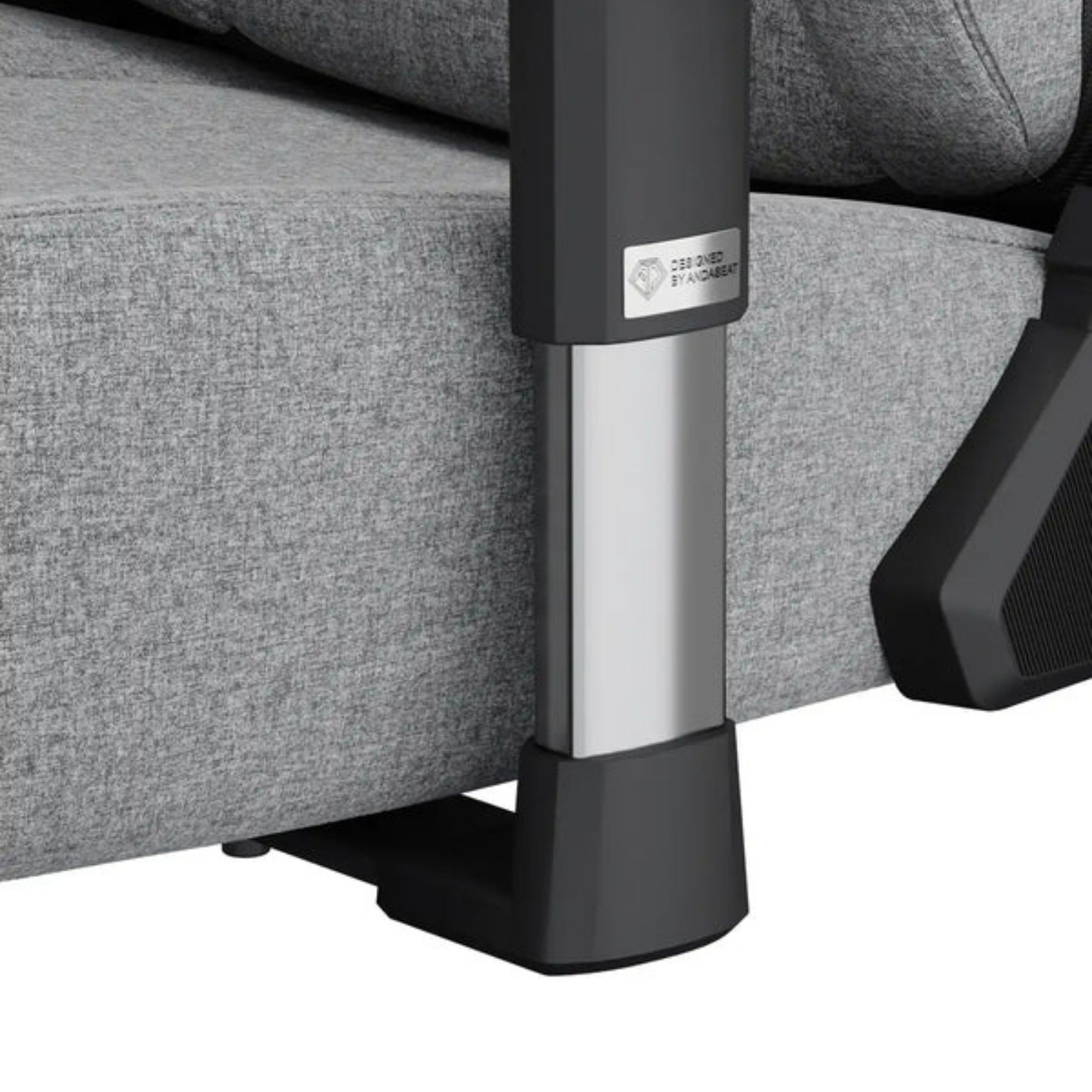 Gros plan sur un pied de chaise noir et argenté. La chaise est grise. Le pied a un design argenté et noir.