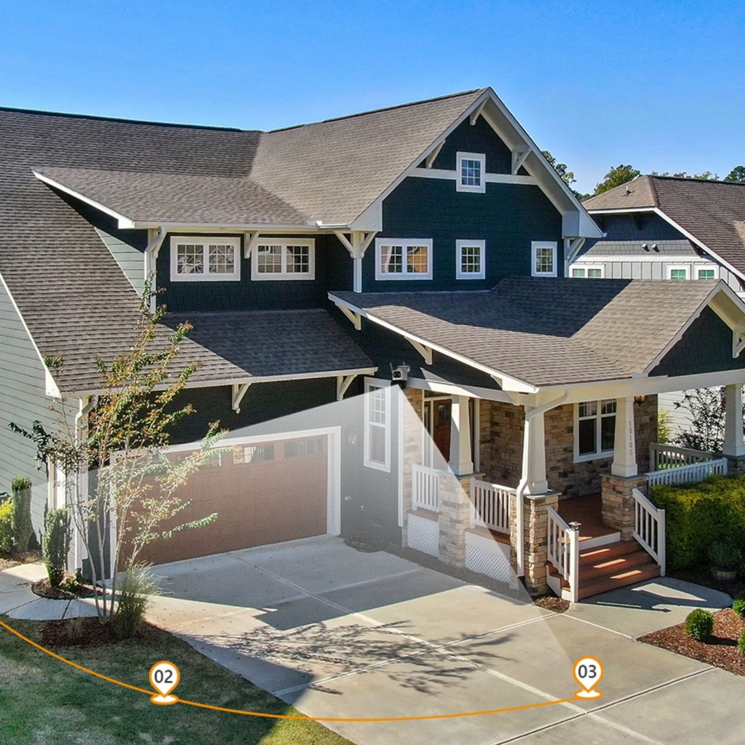 Elewacja domu z zielonym sidingiem i ciemnym dachem. Widoczny podjazd, ganek i podwórze, z oświetleniem bezpieczeństwa.