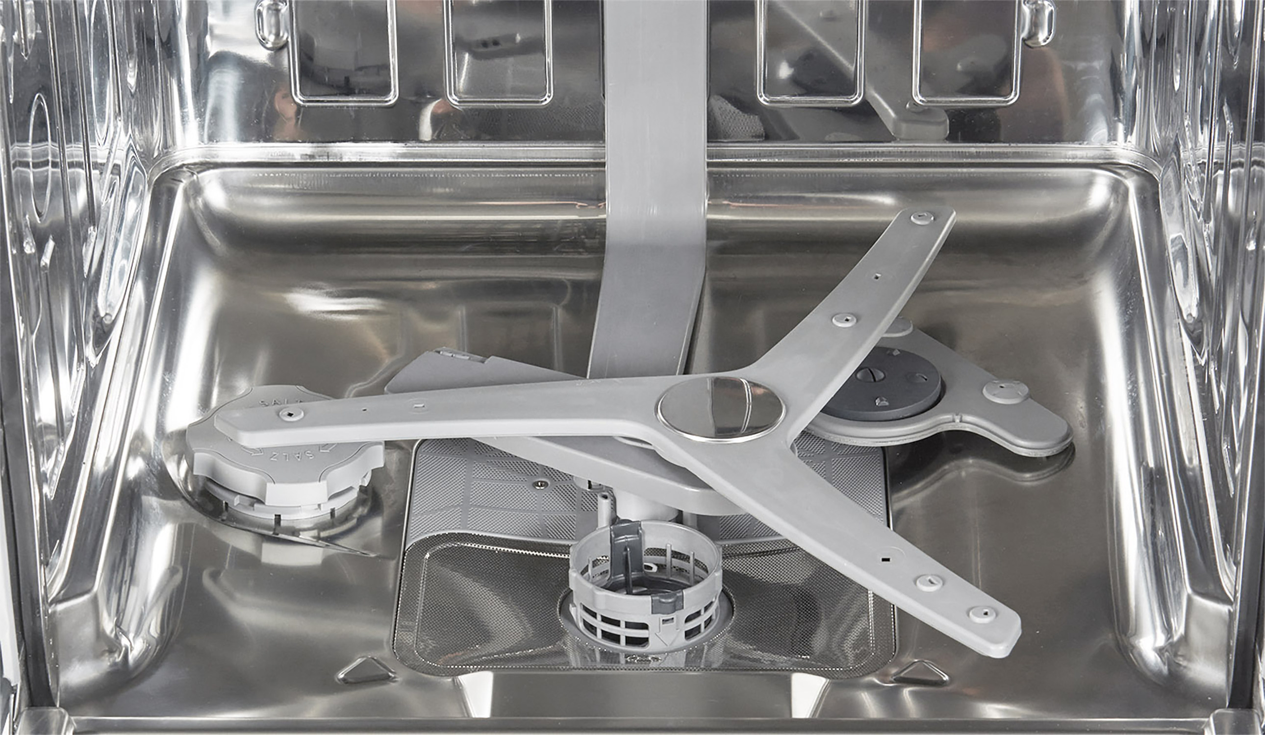 Wnętrze zmywarki, pokazujące ramiona spryskujące i filtr.