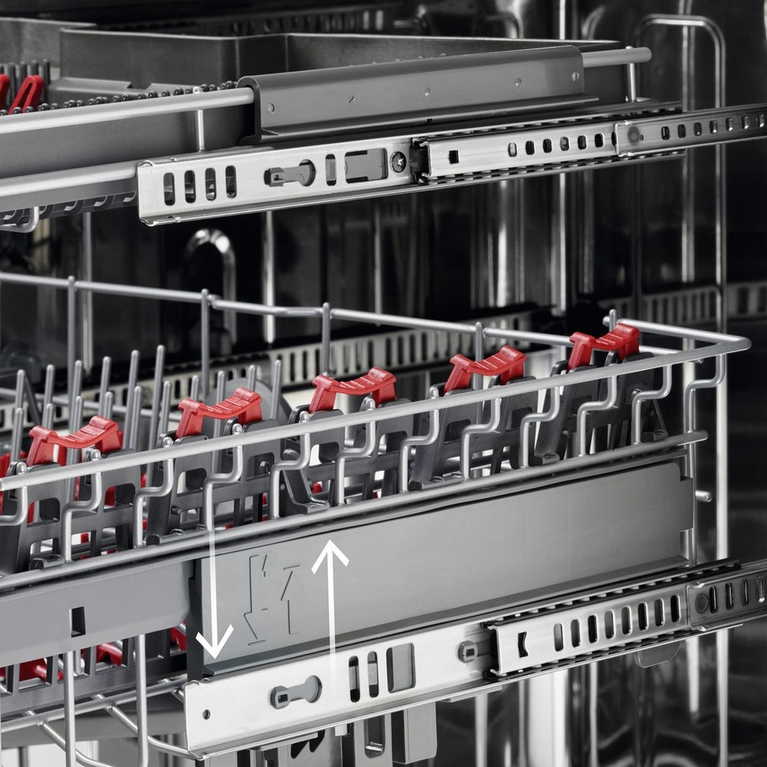 Wnętrze zmywarki z koszami i czerwonymi klipsami.