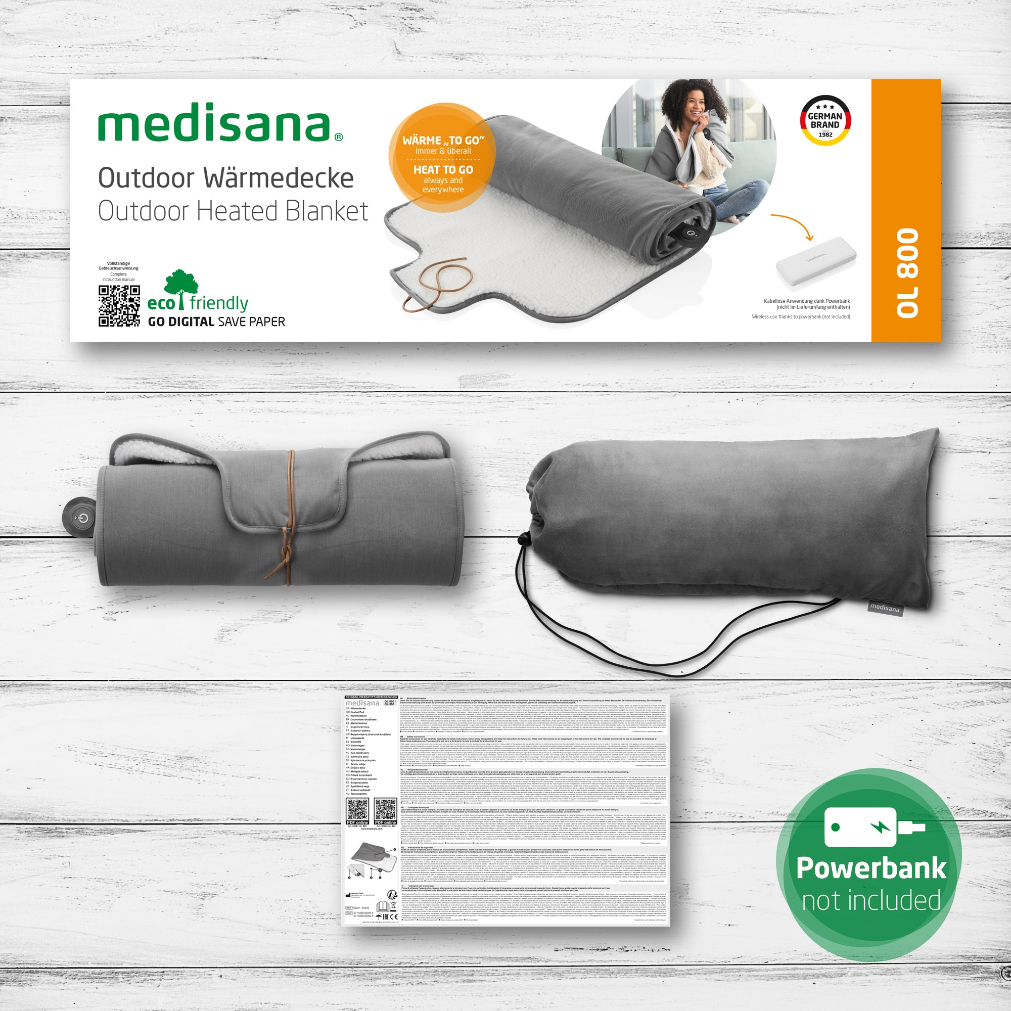 Ein Produktkarton mit einer Heizdecke und Powerbank, mit Text und Bildern.