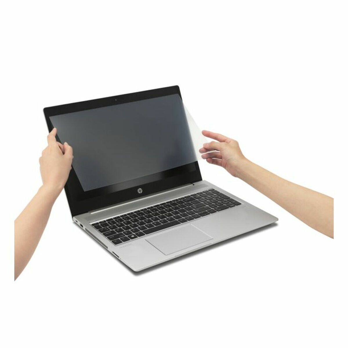 Manos aplicando un protector de pantalla en una pantalla de portátil. El portátil es plateado y abierto.