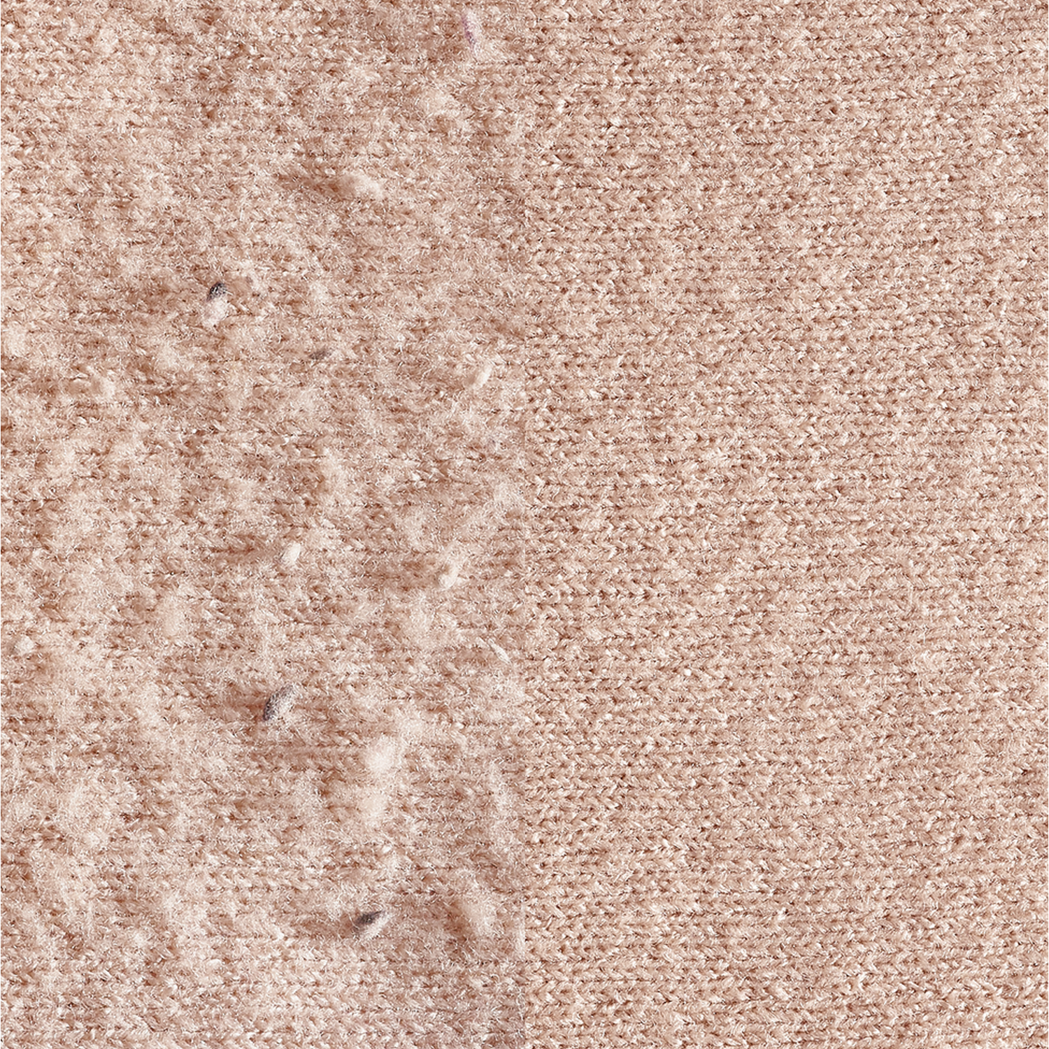 Nahaufnahme eines pfirsichfarbenen Strickstoffs. Auf der linken Seite ist etwas Flusen zu sehen.