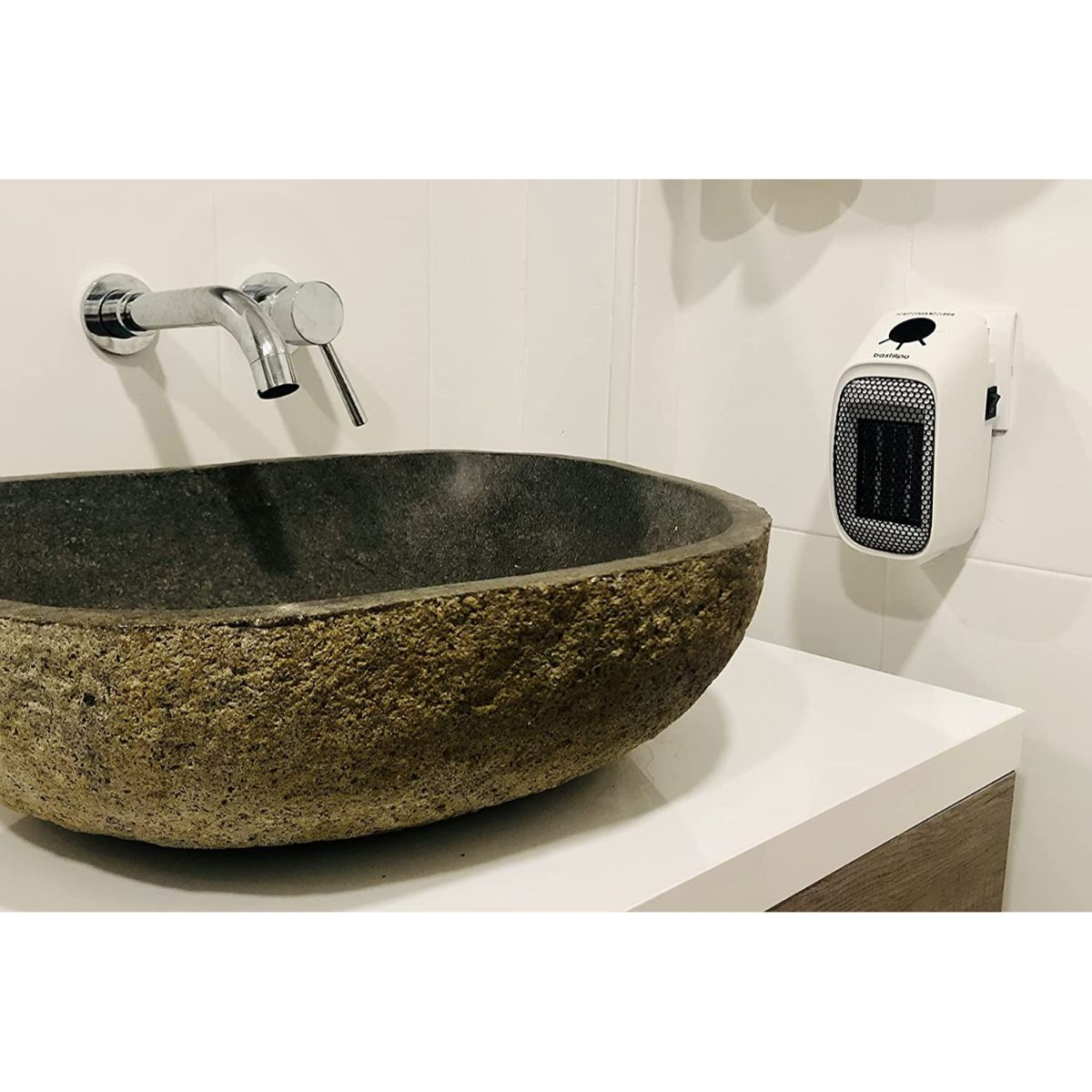 Scena bagno con lavabo in pietra, rubinetto e scaldabagno a parete bianco.