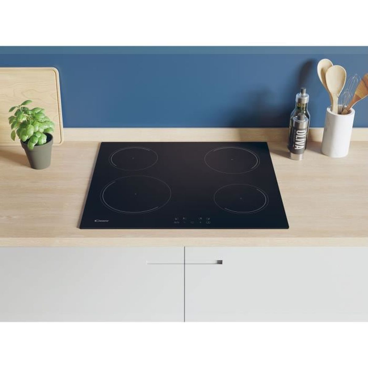 Een zwarte inductiekookplaat met vier cirkelvormige branders. Hij staat op een houten aanrechtblad.
