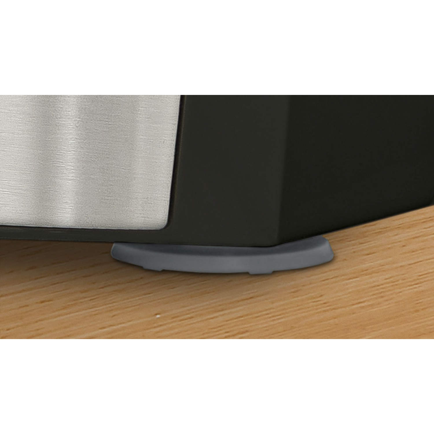 Zbliżenie szarego gumowego wspornika nóżki urządzenia na drewnianej powierzchni.