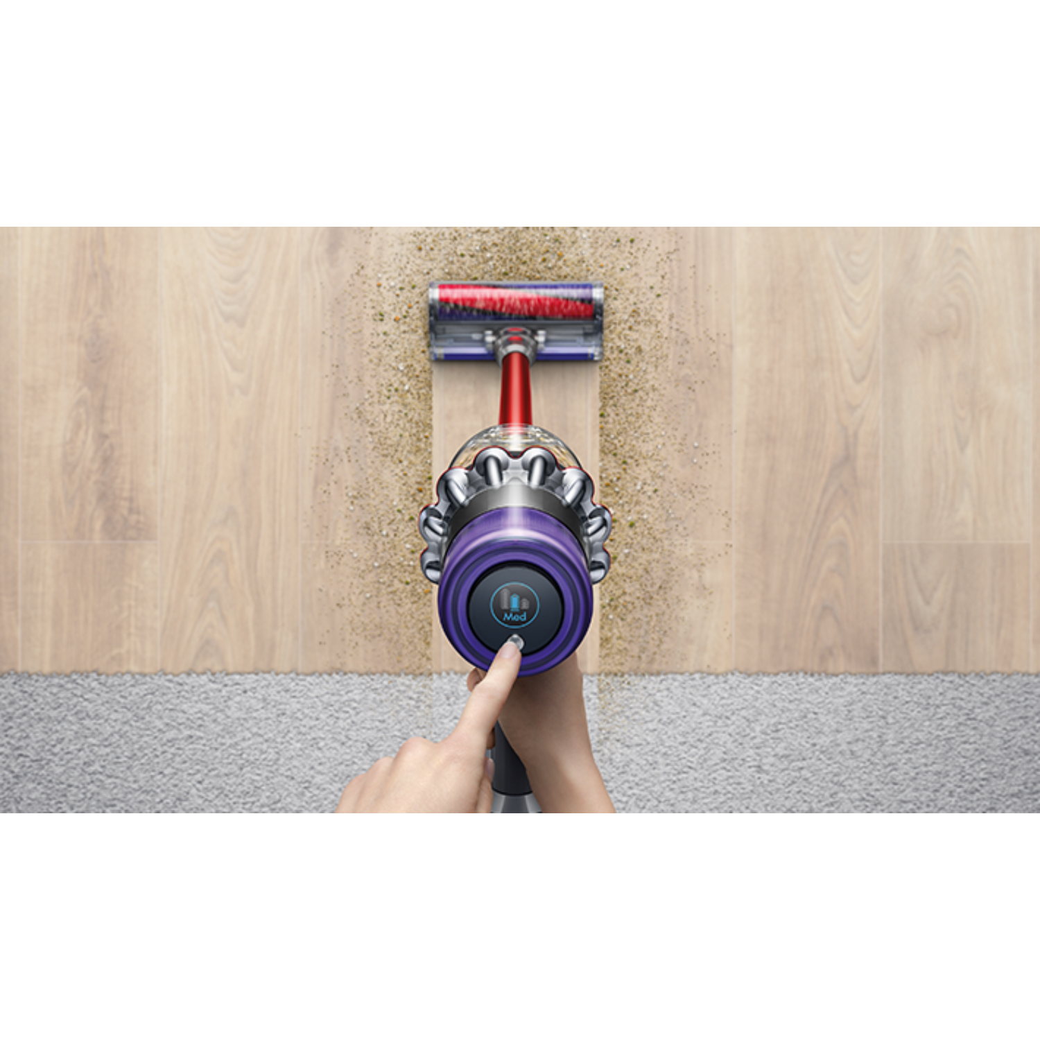 Widok z góry na osobę odkurzającą drewnianą podłogę fioletowym odkurzaczem.