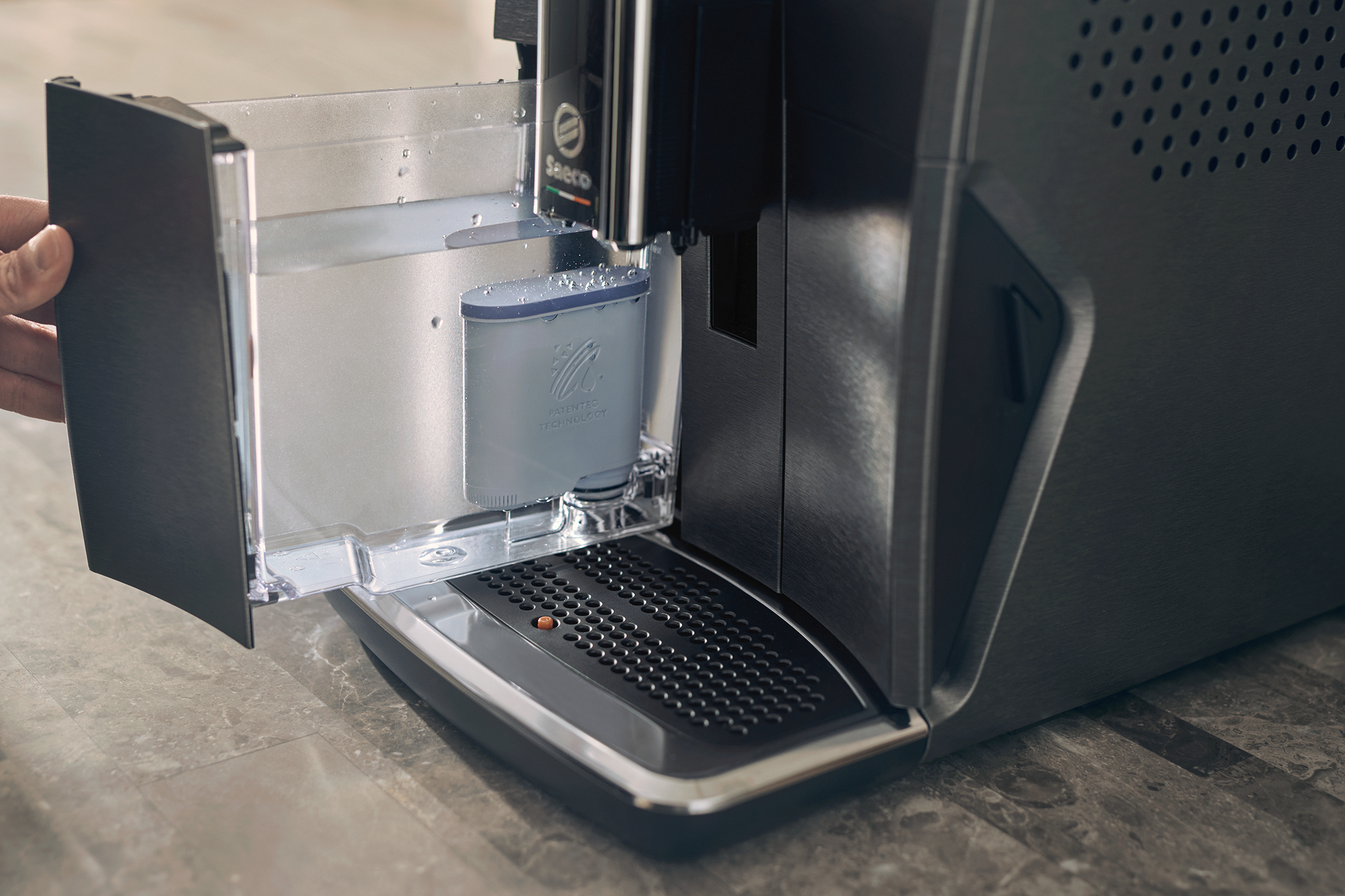 Espressomaschine mit geöffnetem Wassertank, zeigt den Filter und das Wasser im Inneren.