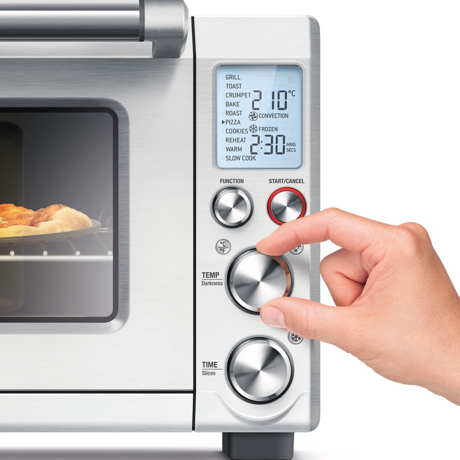 Ręka obracająca pokrętło na srebrnym i białym piekarniku z wyświetlaczem pokazującym ustawienia.