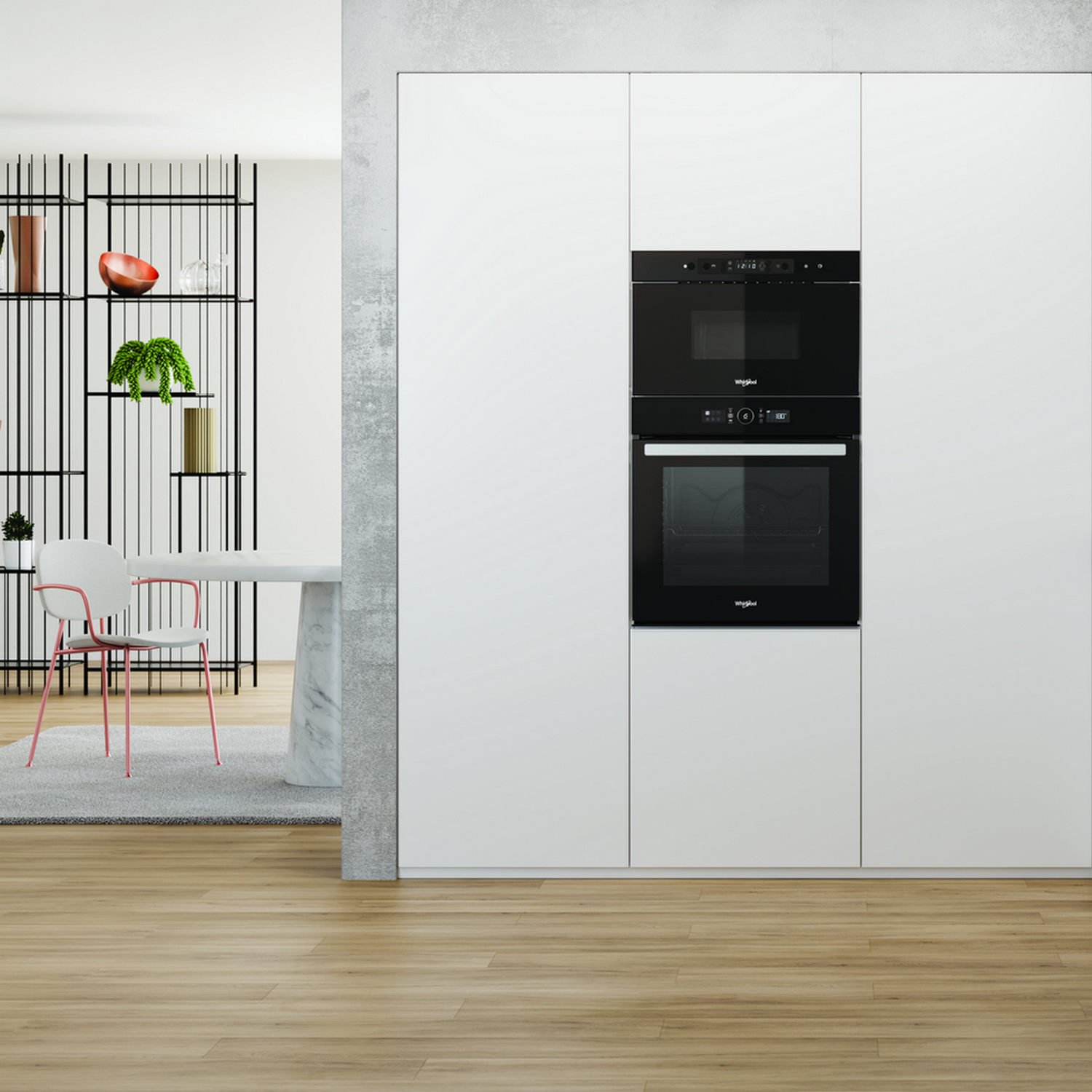 Cocina moderna con armarios blancos, horno y microondas empotrados, y mesa con silla rosa.