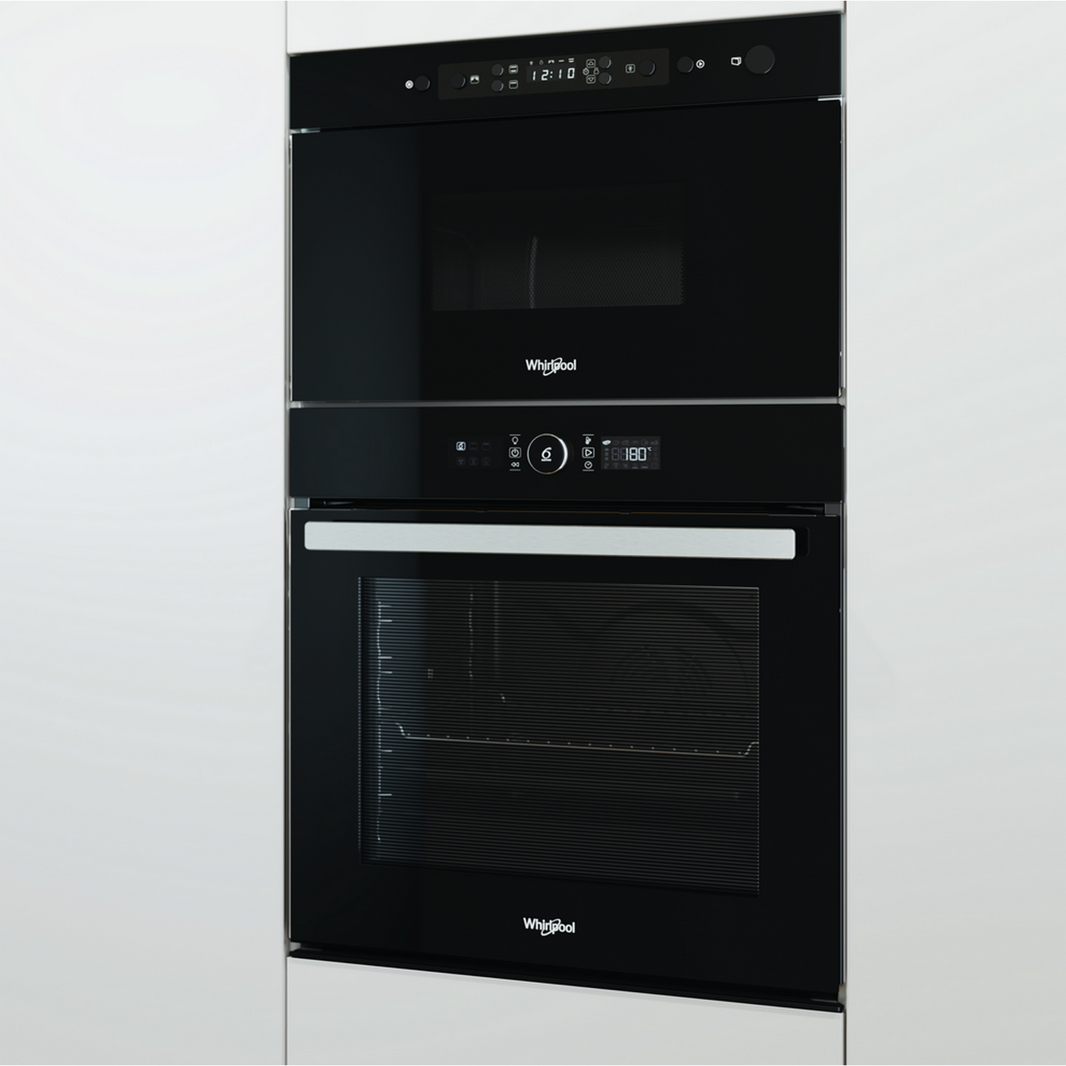 Microondas y horno Whirlpool negros. Gabinetes blancos al fondo.