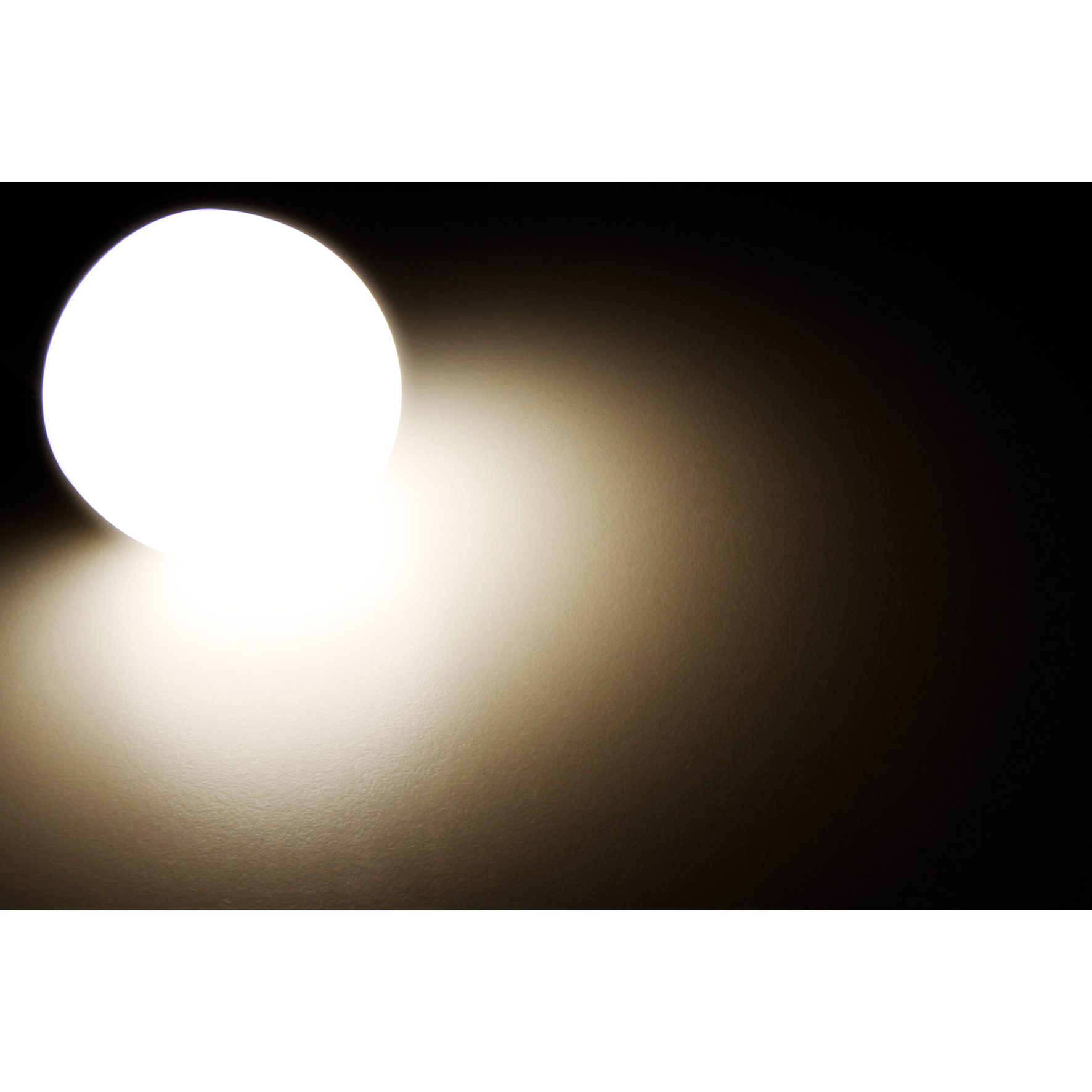 Ein helles, weißes, kreisförmiges Licht, das Licht auf dunklem Hintergrund abgibt.