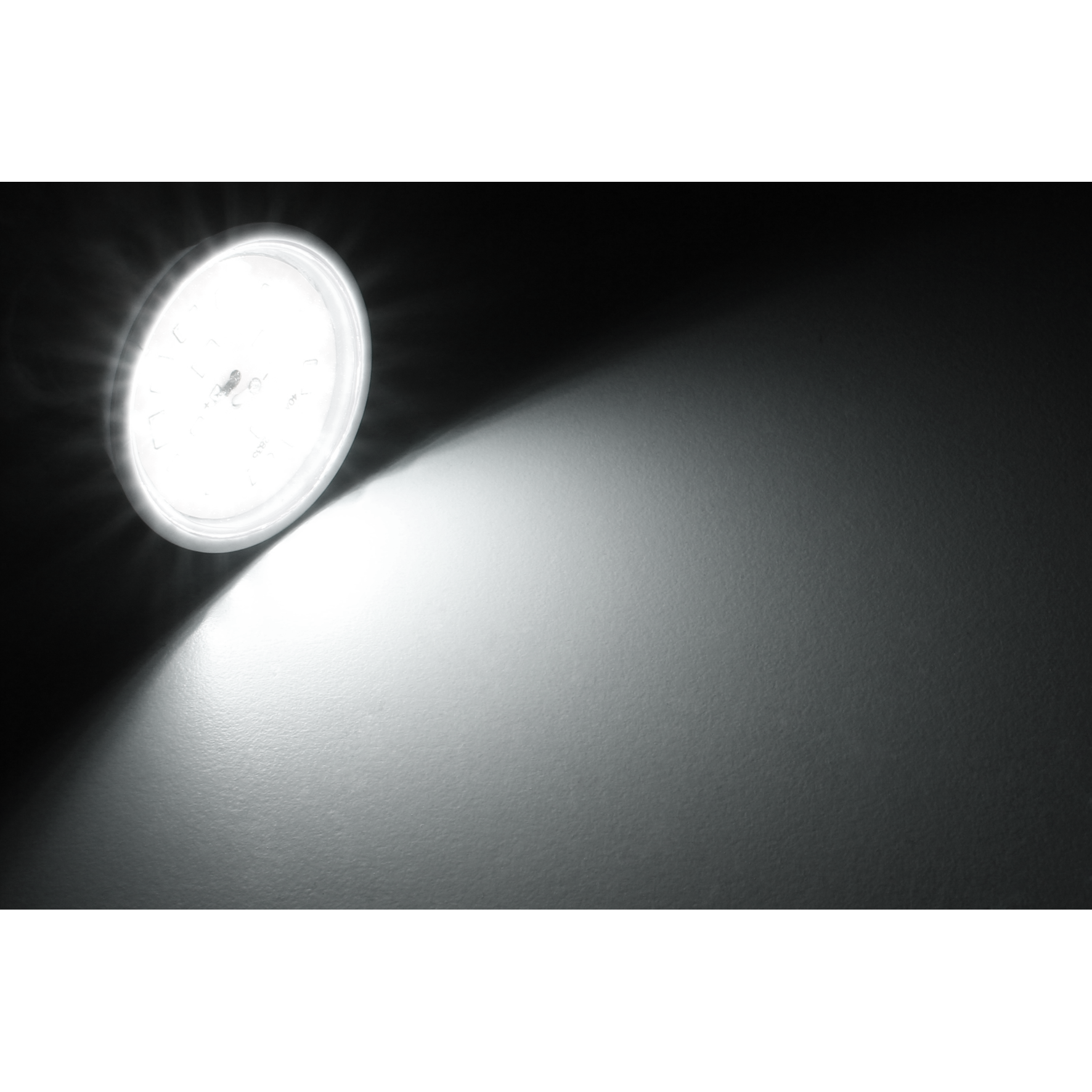 Eine runde Lichtquelle, die eine Oberfläche beleuchtet, mit einem schwarzen Hintergrund.
