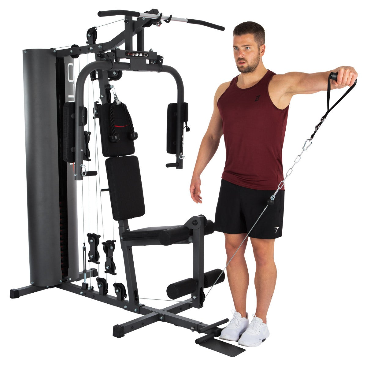 Mann, der ein Finnlo Multi-Gym benutzt, trägt ein weinrotes Tanktop, schwarze Shorts, weiße Schuhe.