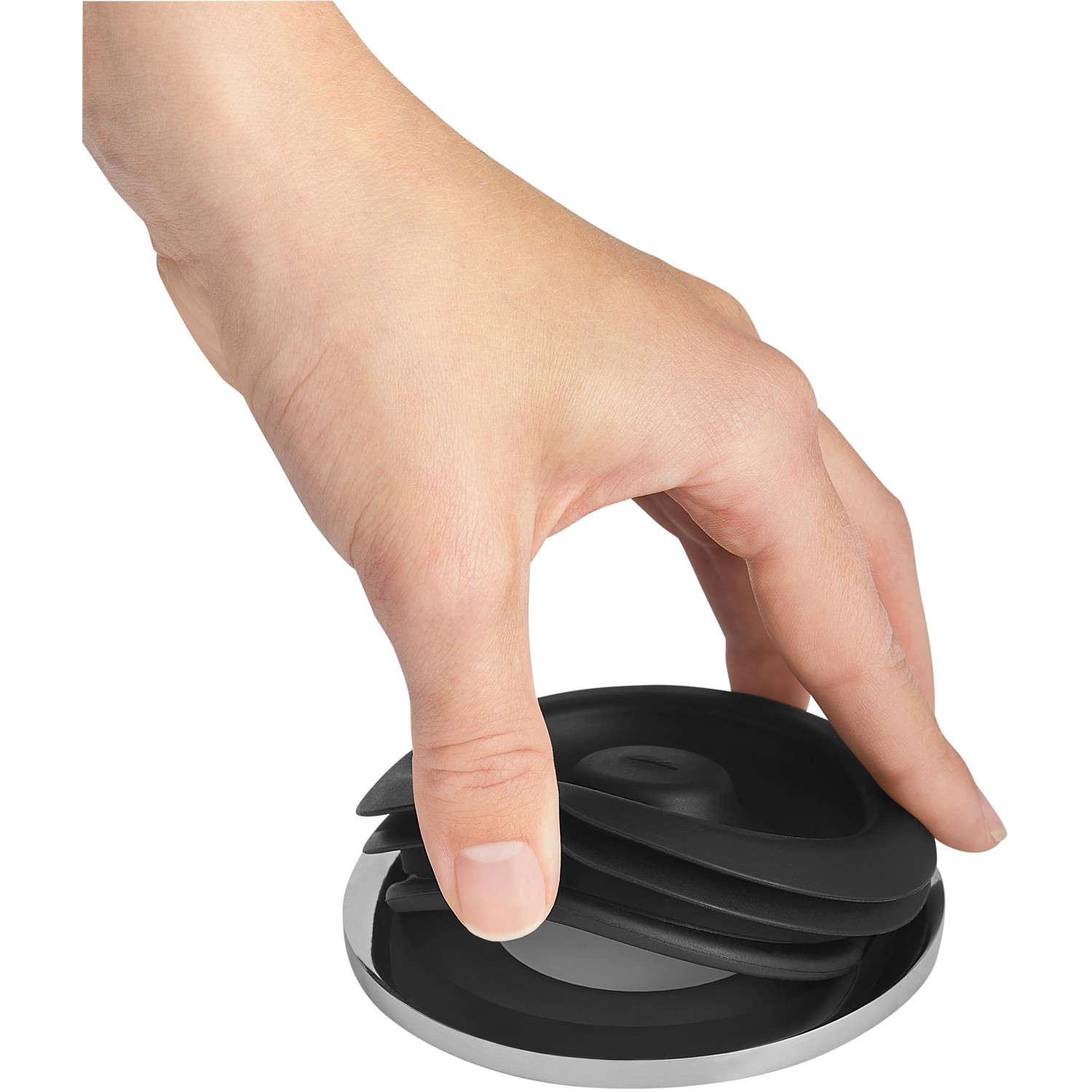 Eine Hand hält einen schwarzen, geschichteten Deckel über einer glänzenden Metallbasis.