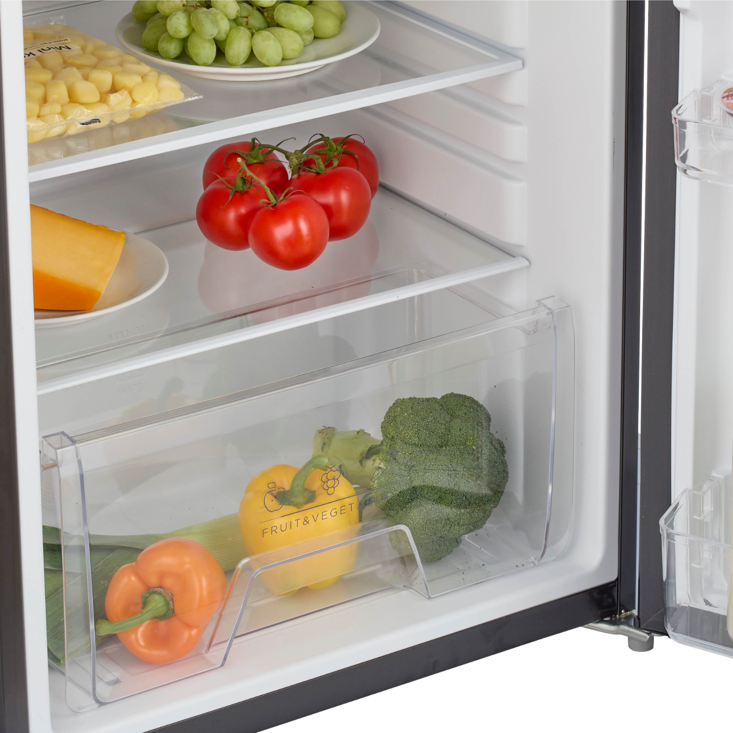 Fridge interior with food items: tomatoes, grapes, cheese, broccoli, and peppers.