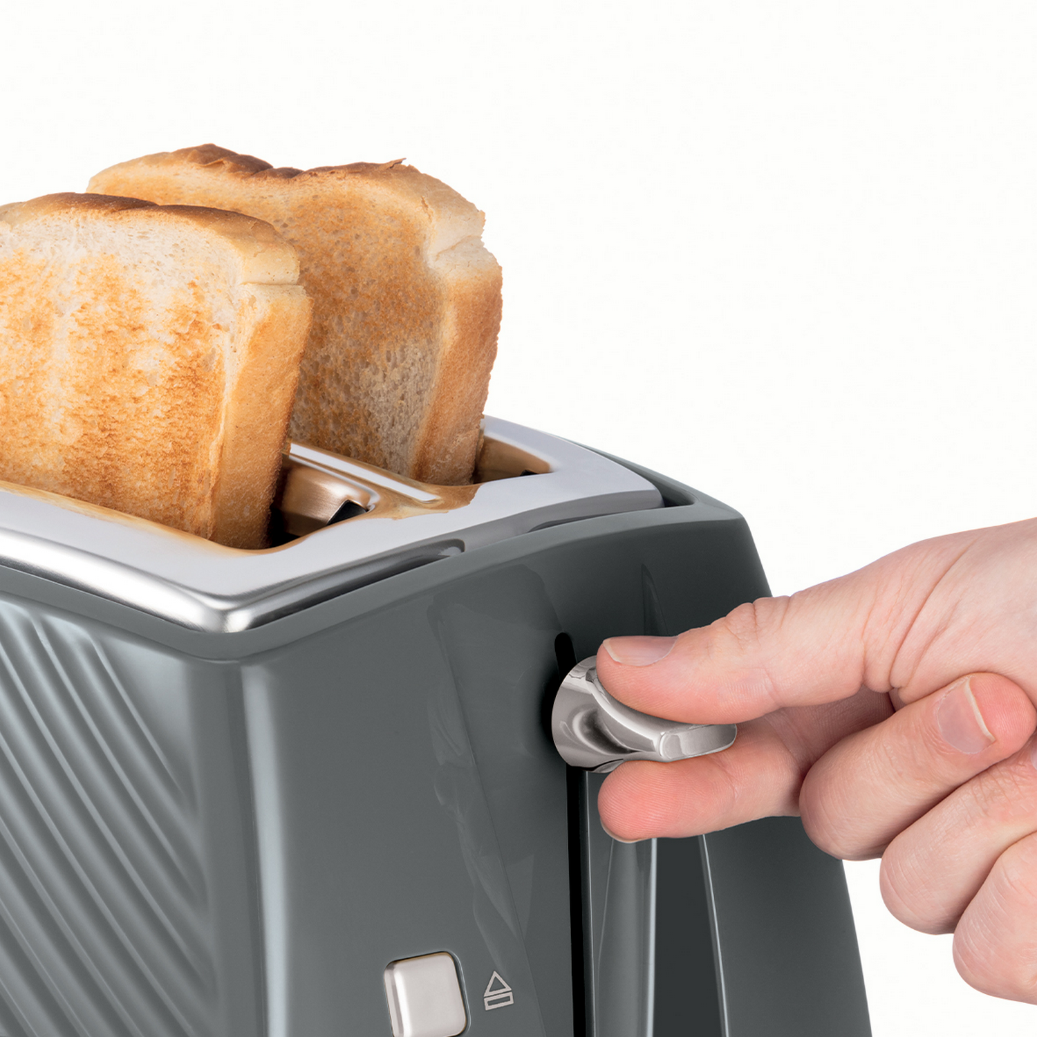 Een hand laat de hendel zakken op een grijze broodrooster met twee sneetjes toast.