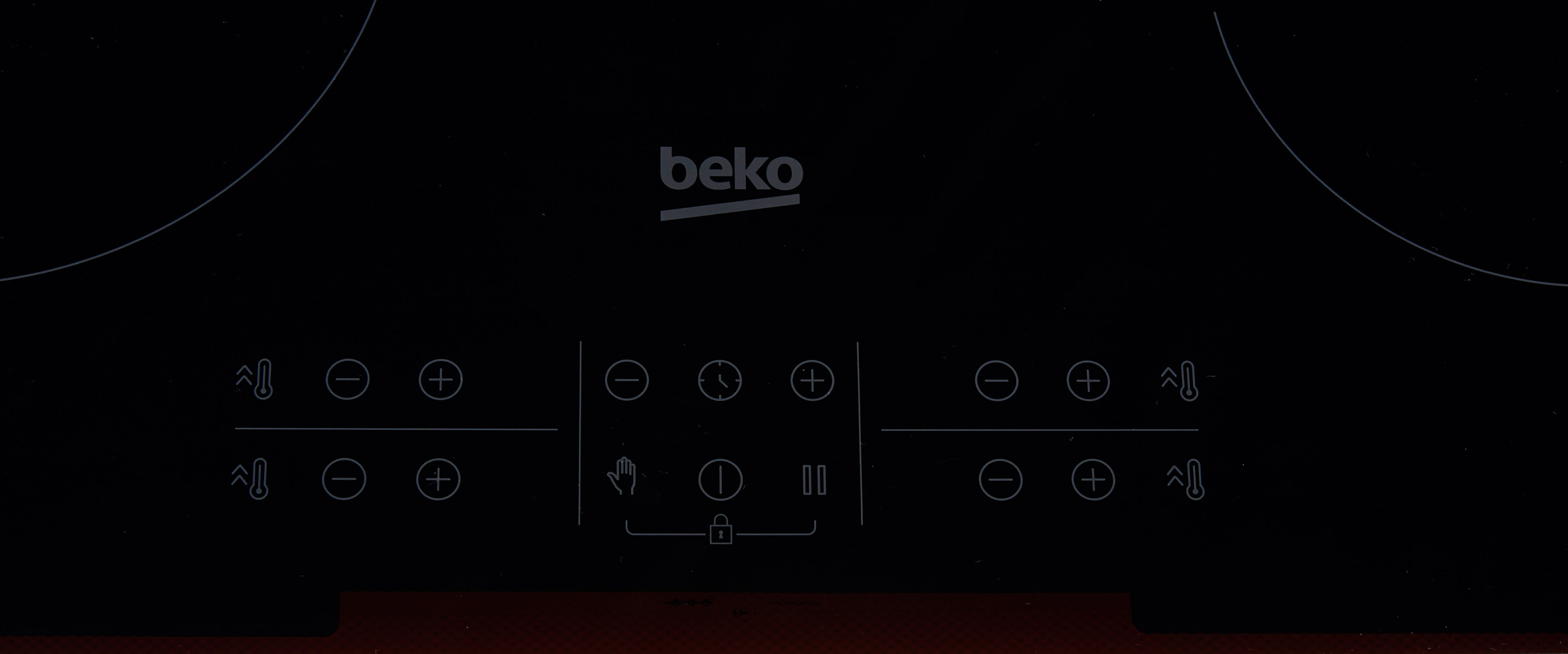 Un piano cottura nero con comandi touch. Il piano cottura ha il logo Beko.