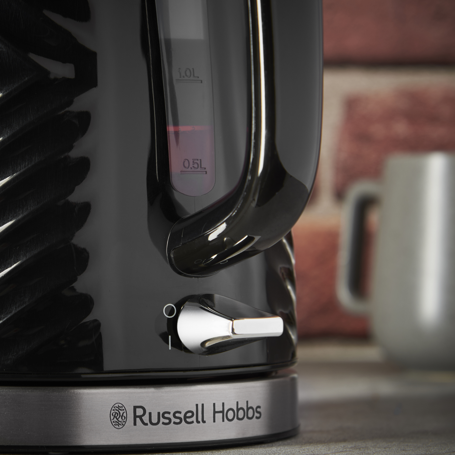 Zbliżenie czarnego czajnika Russell Hobbs ze wskaźnikami poziomu wody.