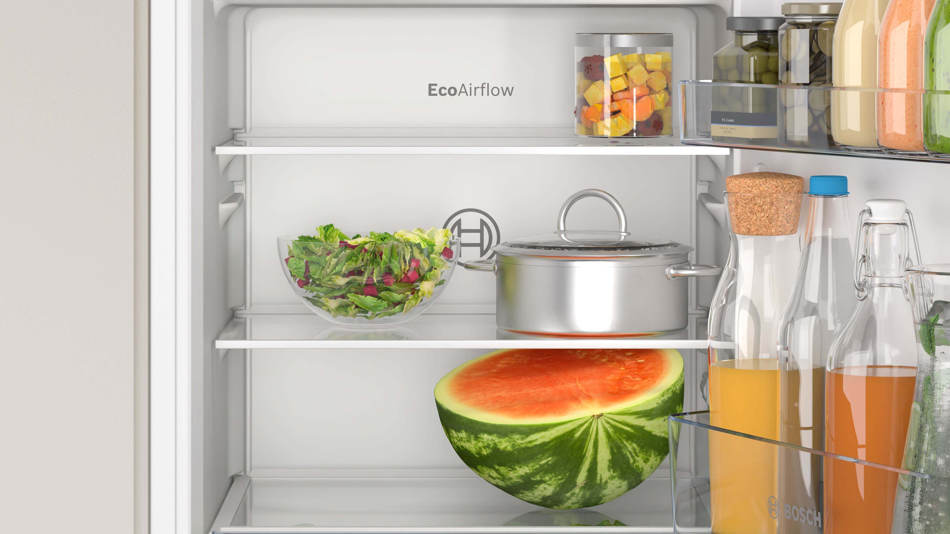 Kühlschrankinnenraum. Salat, Wassermelone und andere Lebensmittel auf Regalen. Weißer Hintergrund.