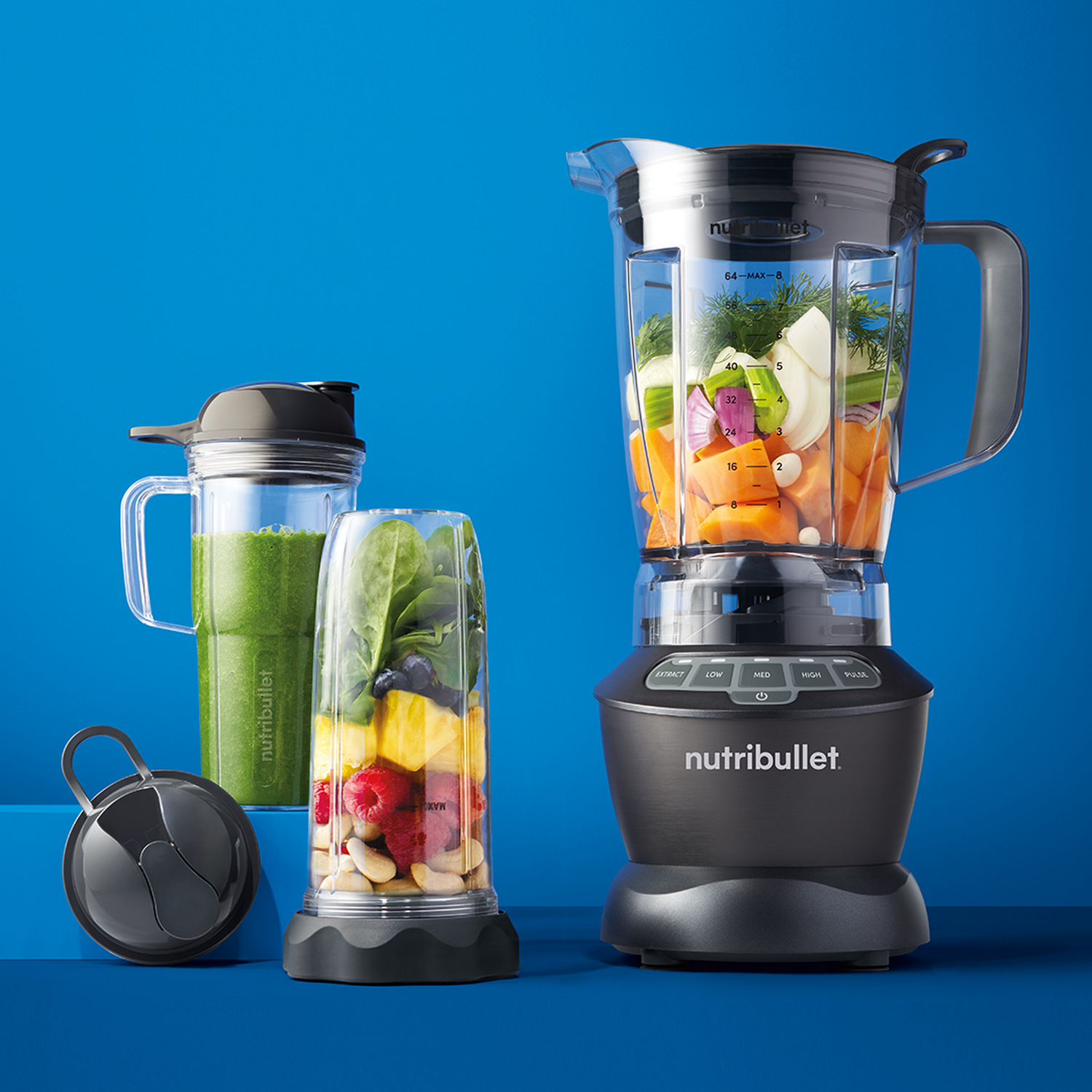 Blenders avec ingrédients. Un rempli de légumes, un autre de fruits. Un troisième avec smoothie vert.