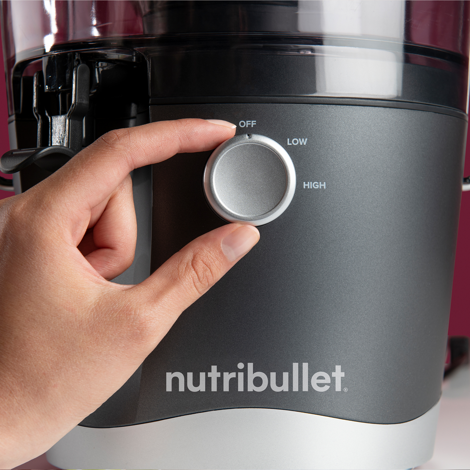 Hand turning a dial on a black and silver Nutribullet appliance. The dial has OFF, LOW, and HIGH settings.