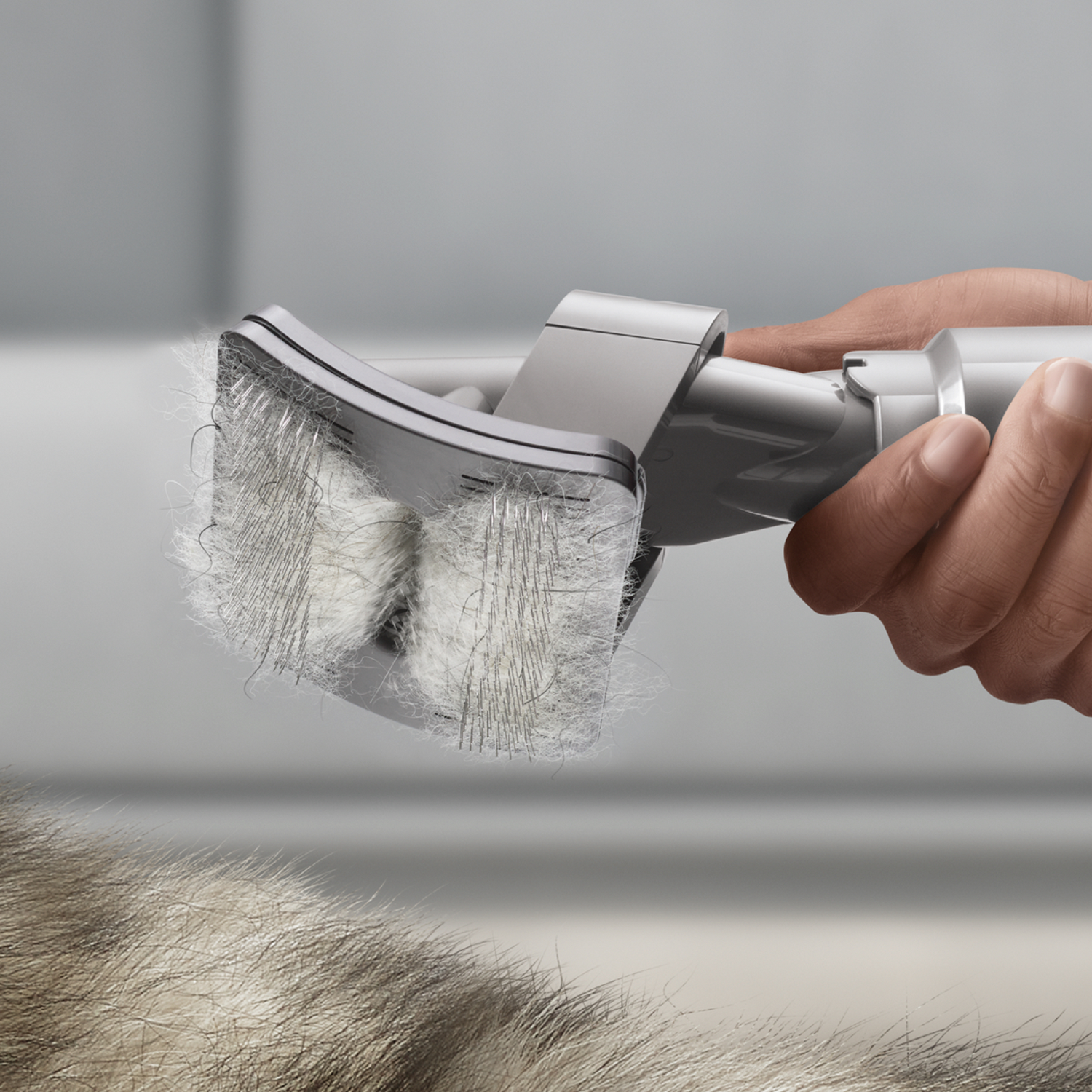 Primo piano di un accessorio per aspirapolvere, che rimuove i peli di animali da una superficie chiara.