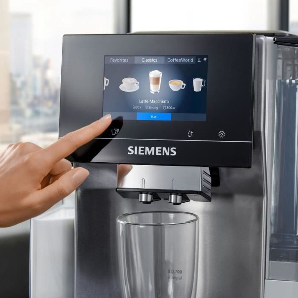 Macchina da caffè Siemens con touchscreen che mostra l'opzione latte macchiato. Bicchiere sotto.